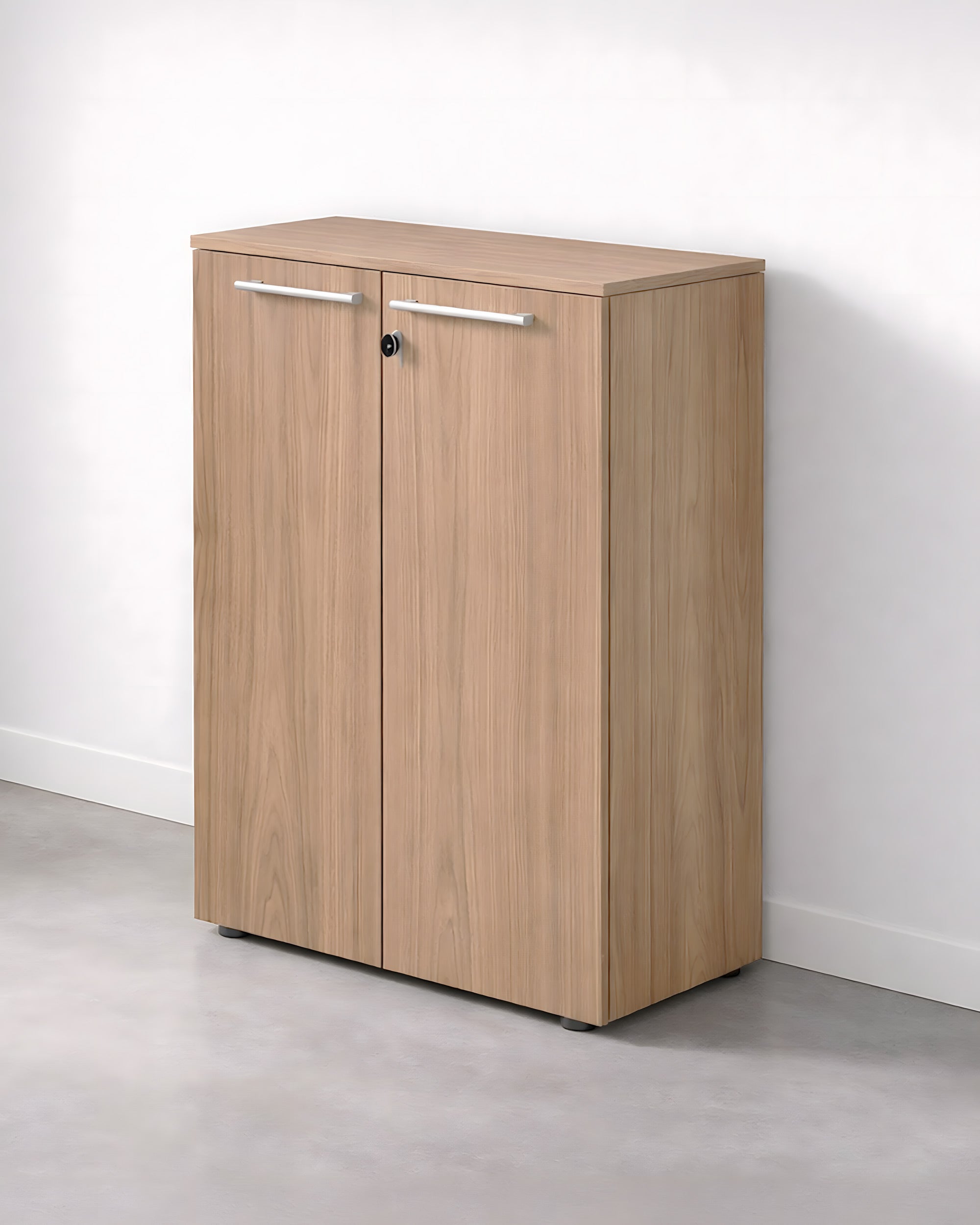 L'Armoire Mi-Haute de Bureau Flora à Portes Battantes de Monsieur Bureau, avec ses deux portes, ses poignées en métal et sa serrure, est idéale pour le rangement de bureau et se place contre un mur blanc sur un sol gris.#finitions_noyer