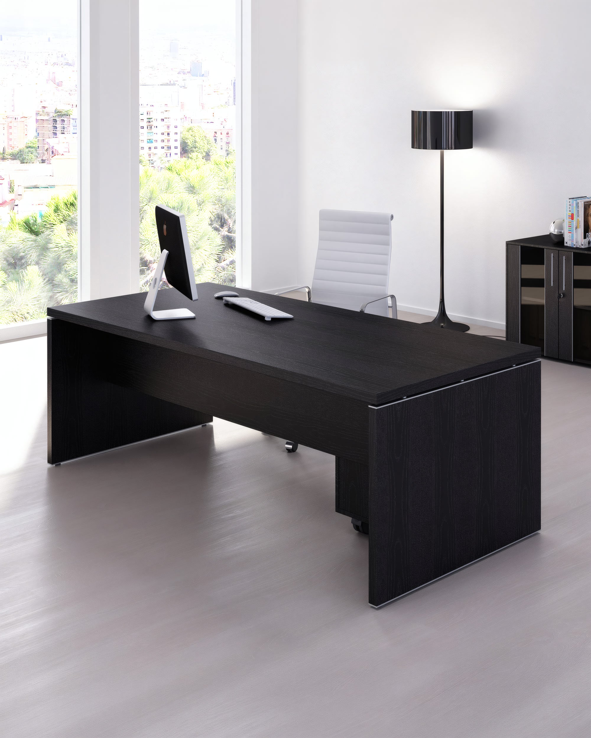 Un bureau moderne avec le Bureau de Direction Flora de Monsieur Bureau - un grand bureau en bois foncé - associé à une chaise pivotante blanche et à un moniteur. Des fenêtres allant du sol au plafond offrent une vue sur la ville ; une lampe et un meuble noirs se trouvent à l'arrière-plan.#finitions plateau_frene_noir