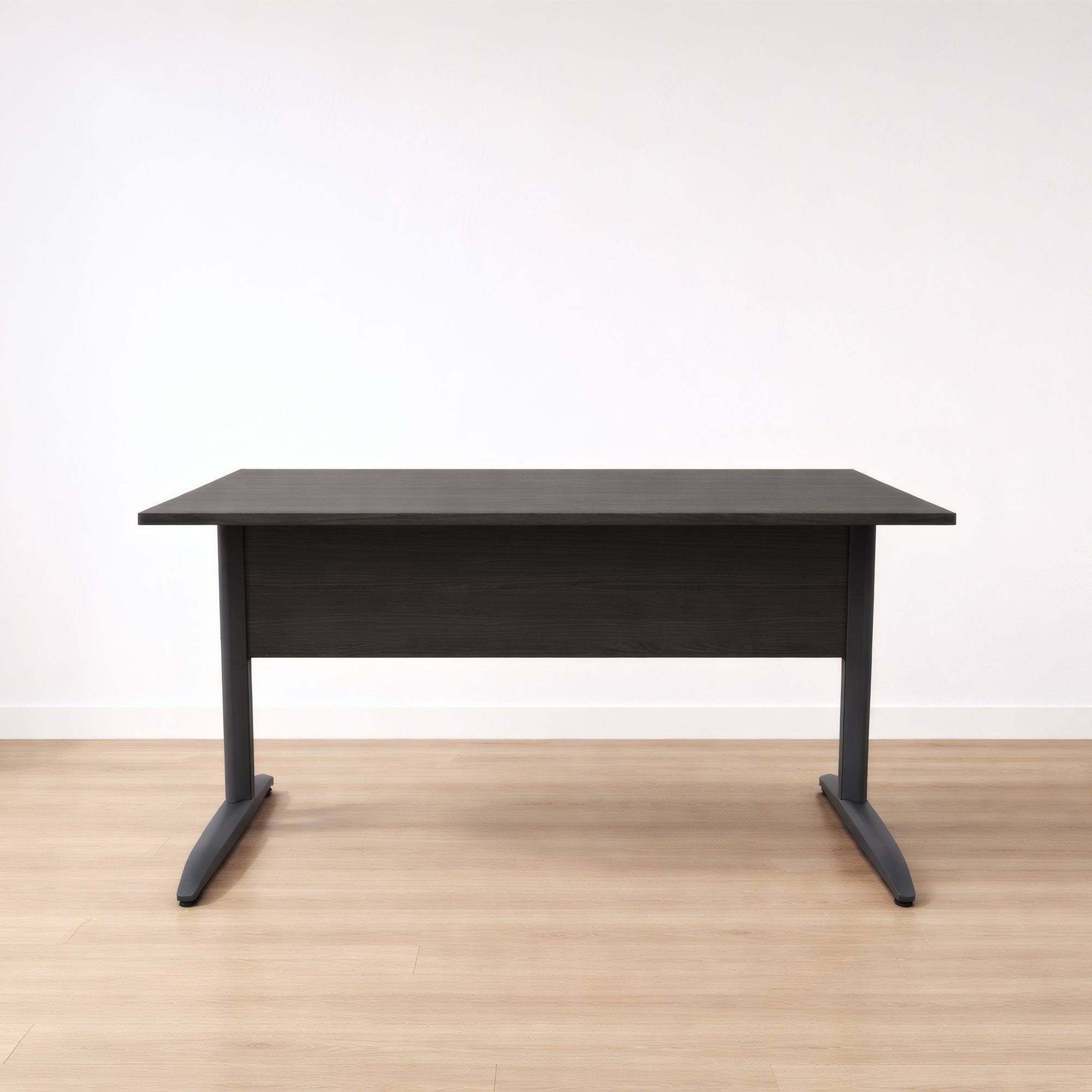 Le Bureau Pro Effect Droit ou Angle Modulable de Monsieur Bureau est un bureau moderne et élégant en bois foncé avec des pieds en métal, posé sur un sol en bois clair contre un mur blanc uni..#combo_frene_noir_anthracite_bureau