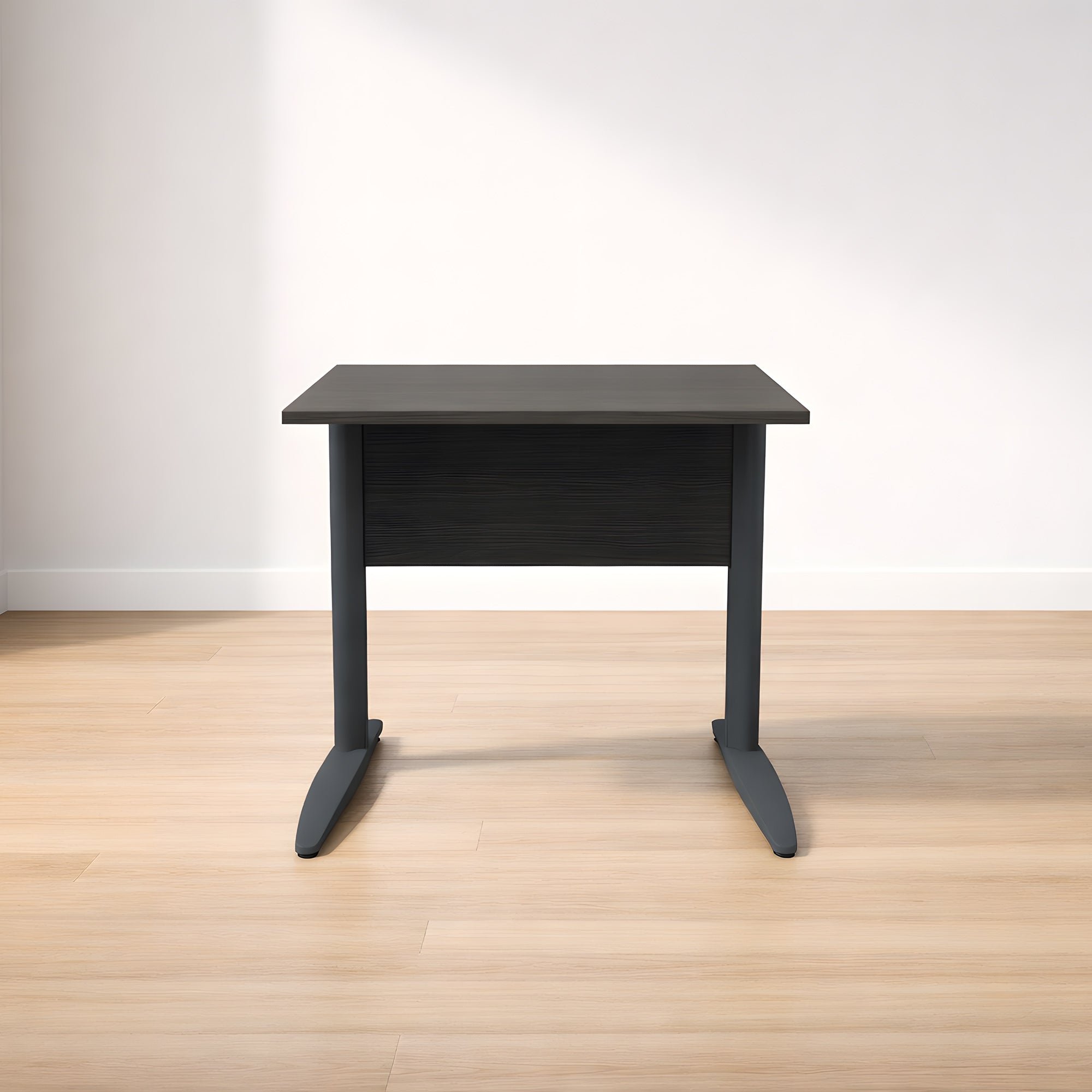 Un Bureau Pro Effect Droit ou Angle Modulable noir compact de Monsieur Bureau avec deux pieds courbés est posé sur un sol en bois clair contre un mur blanc uni.#combo_frene_noir__anthracite_l80xp80
