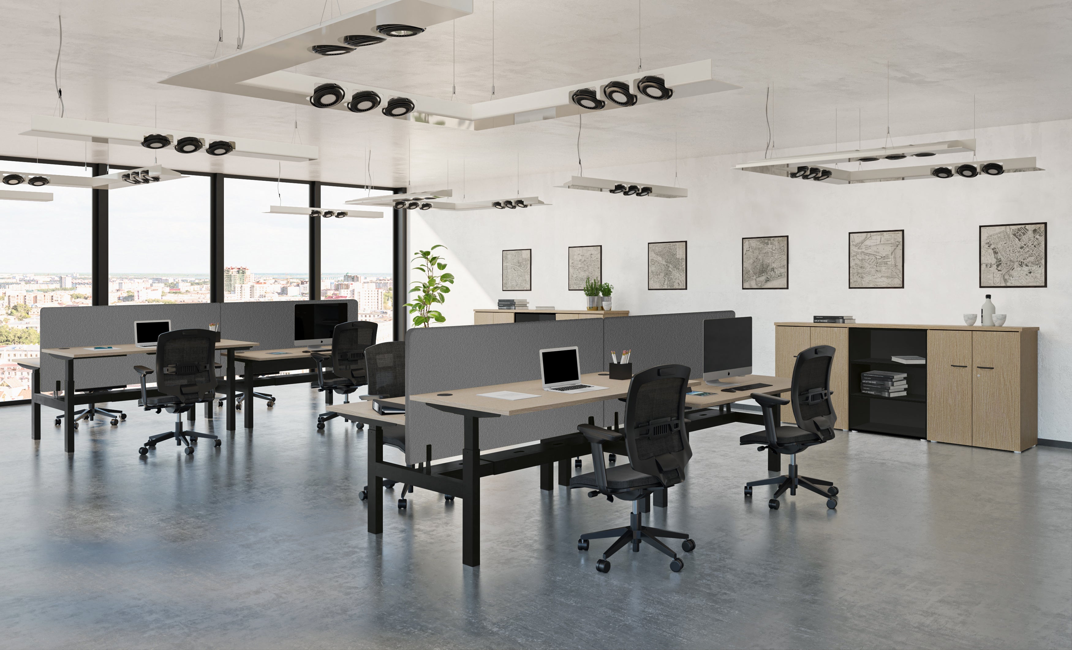Un bureau moderne à aire ouverte, composé de plusieurs bureaux, de chaises noires et d'écrans, est équipé de la banquette Bureau Assis-Debout Top & Down 2 Personnes de Monsieur Bureau, qui favorise le travail ergonomique. De grandes fenêtres inondent l'espace de lumière et offrent une vue sur la ville.