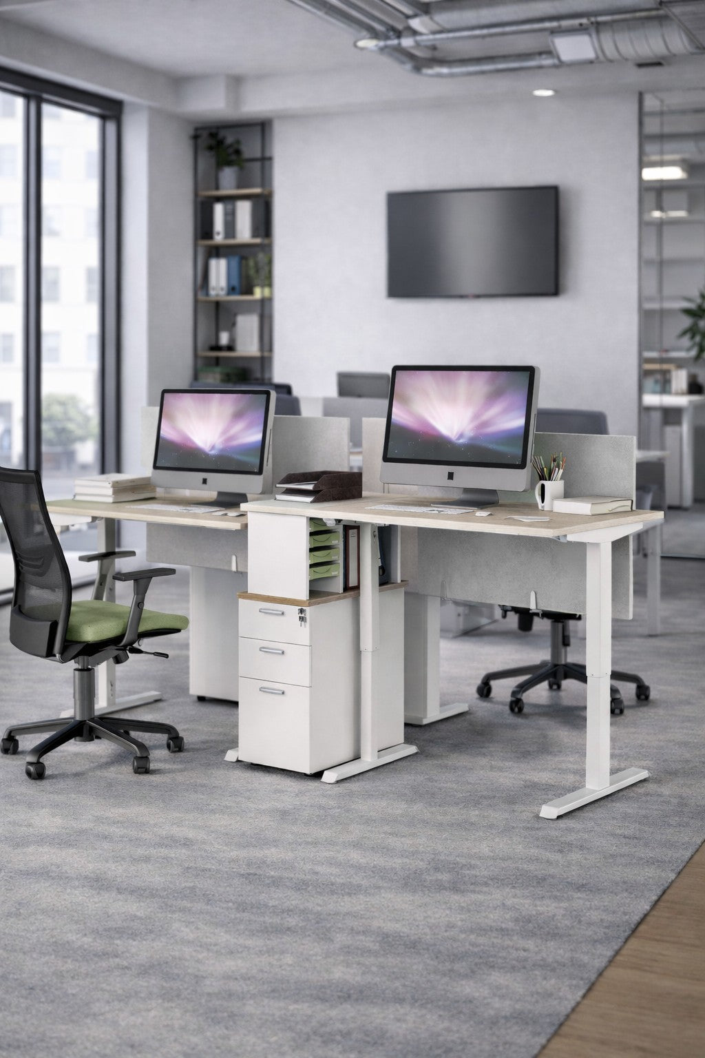 Bureau moderne avec deux bureaux Monsieur Bureau Bureau Électrique Assis-Debout Pro ECO-UP PLUS Double Moteur, chacun équipé d'un écran, d'une chaise et de fournitures. De grandes fenêtres offrent une lumière naturelle ; des étagères et un décor complètent l'espace de travail ergonomique.