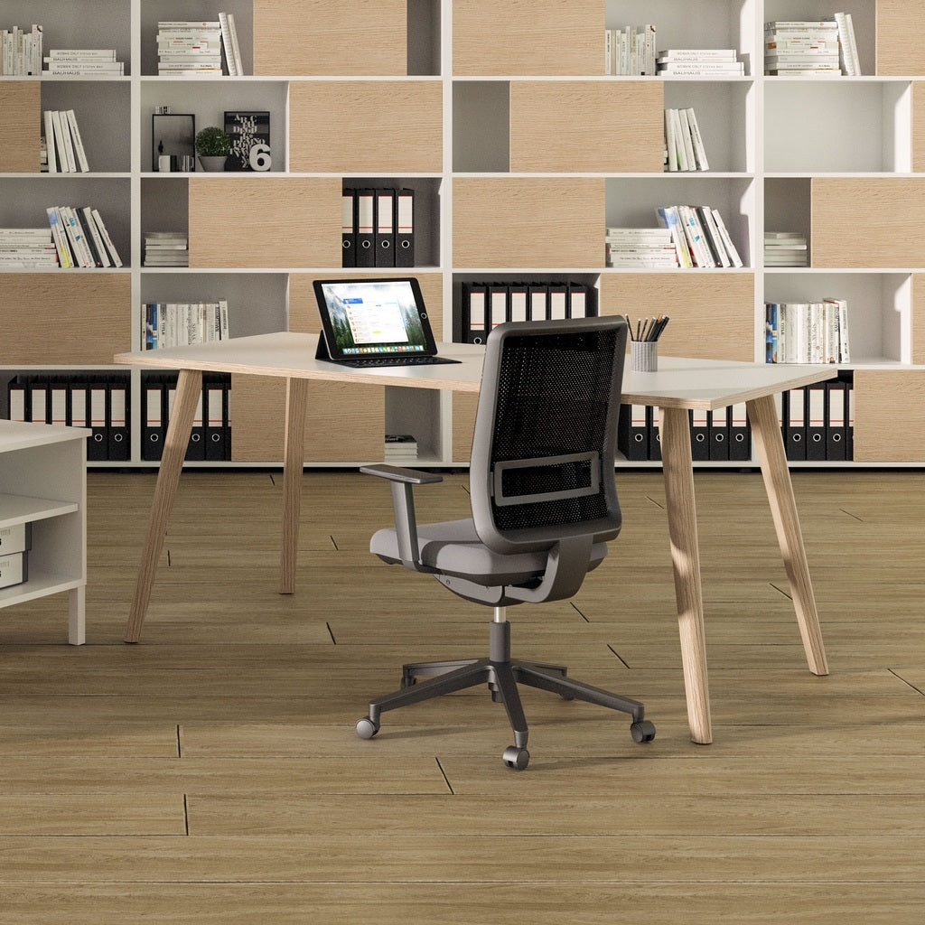 Un bureau moderne avec le Bureau Droit Nature Wood style Scandinave de Monsieur Bureau, un ordinateur portable, une chaise grise en maille, et des étagères remplies de livres et de décorations sur un sol en bois au design scandinave.