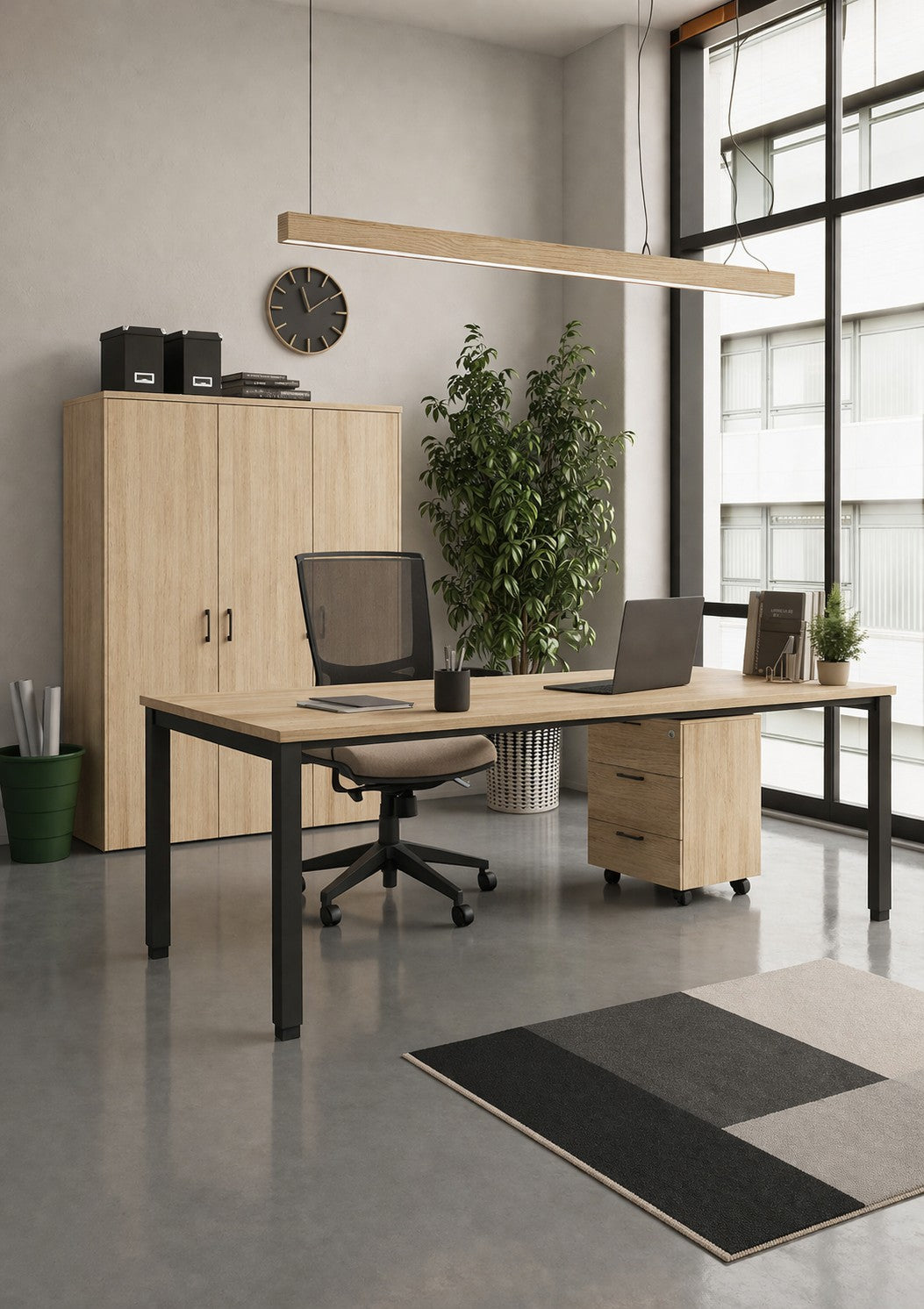 Bureau moderne comprenant un Monsieur Bureau "Bureau professionnel individuel Tempo P60 cm", deux ordinateurs portables, des chaises de bureau, une armoire, une plante en pot, une horloge murale, un tapis et de grandes fenêtres. L'espace est propre et minimaliste et bénéficie de la lumière naturelle.