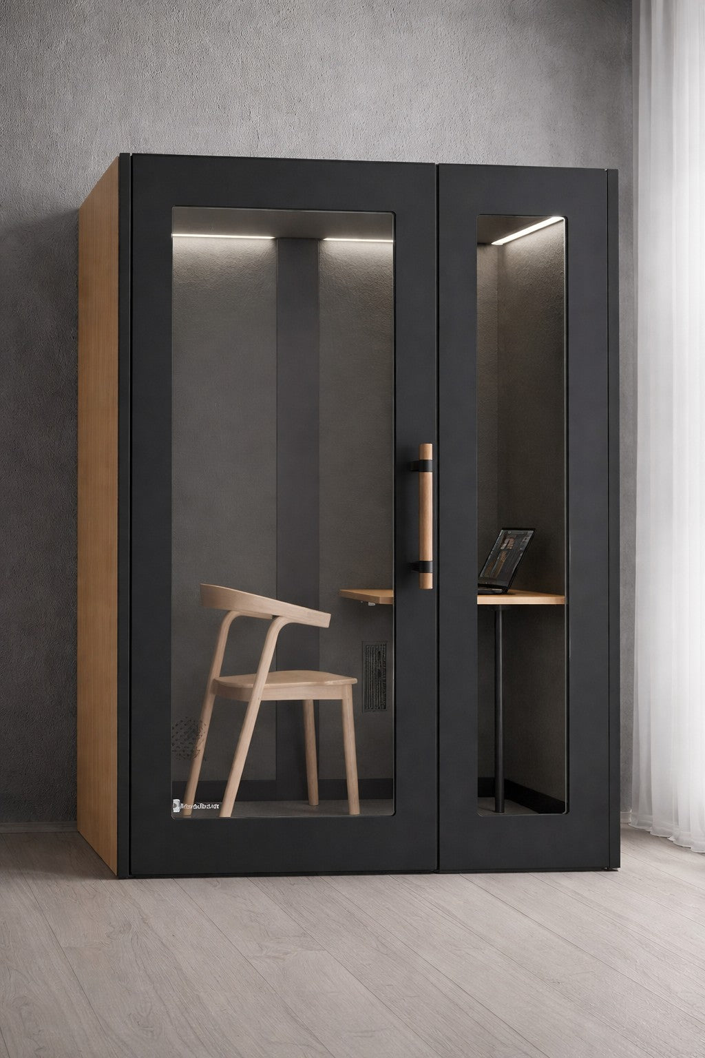 La Cabine acoustique de Travail NO SOUND Standard 1 pers de Monsieur Bureau est un bureau moderne avec des portes en verre, une chaise en bois, un bureau et un ordinateur portable, placés contre un mur gris avec un sol en bois clair et des rideaux transparents.