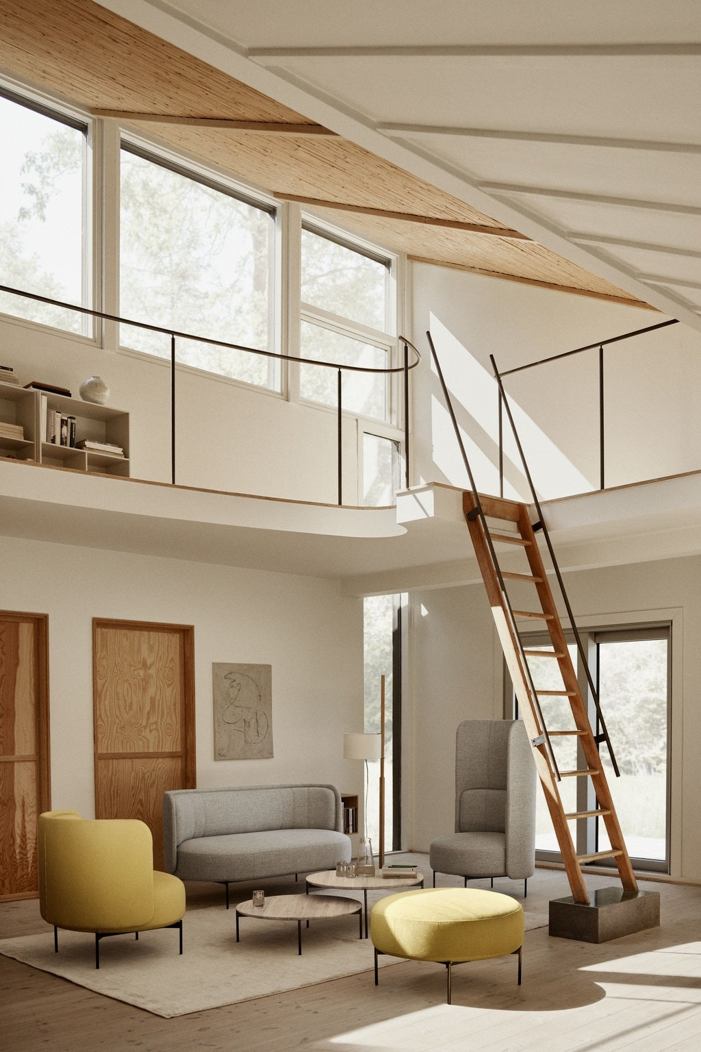 Un salon moderne et ensoleillé avec de grandes fenêtres, une échelle de loft en bois, un canapé et un fauteuil gris, le Fauteuil lounge dossier bas Jal de Monsieur Bureau et un ottoman jaune, des accents de bois clair et un décor minimaliste conçu dans un esprit d'éco-conception.