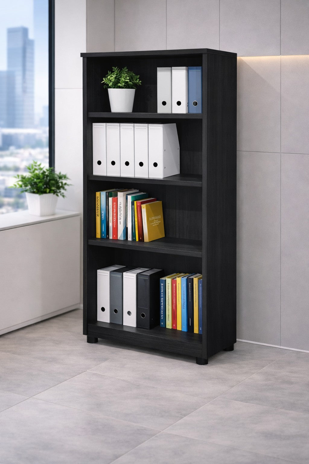 L'Armoire ouverte haute H180 Effect & Budget de Monsieur Bureau, une étagère ouverte noire en bois mélaminé, se trouve dans un coin de bureau moderne avec trois étagères pour les classeurs et les livres. Une plante verte en pot est posée sur le dessus ; une autre plante et une fenêtre se trouvent à proximité.#finitions_frene_noir