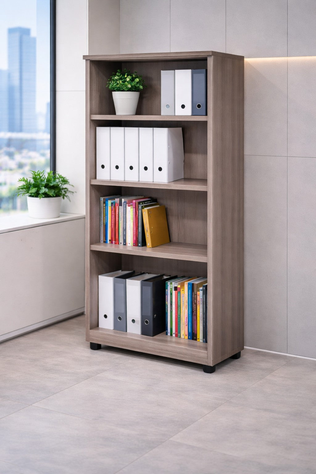 L'Armoire ouverte haute H180 Effect & Budget de Monsieur Bureau se trouve dans un coin de bureau moderne, offrant un rangement vertical pour des classeurs, des livres colorés et une plante verte. De grandes fenêtres avec vue sur la ville et une autre plante en pot se trouvent à proximité.#finitions_frene_de_toscane