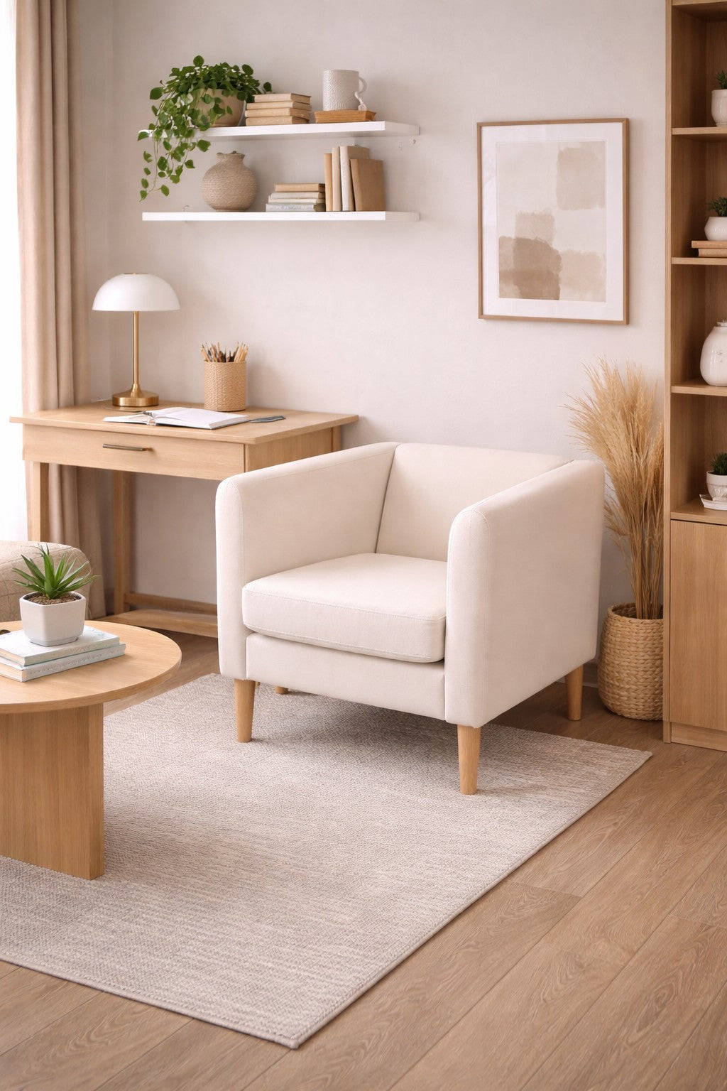 Un salon moderne et confortable présente le Fauteuil d'accueil Kanto pieds bois - Design Scandinave de Monsieur Bureau sur un tapis clair, à côté d'un bureau en bois, d'étagères flottantes avec des plantes, et d'un décor neutre et doux à la lumière naturelle.