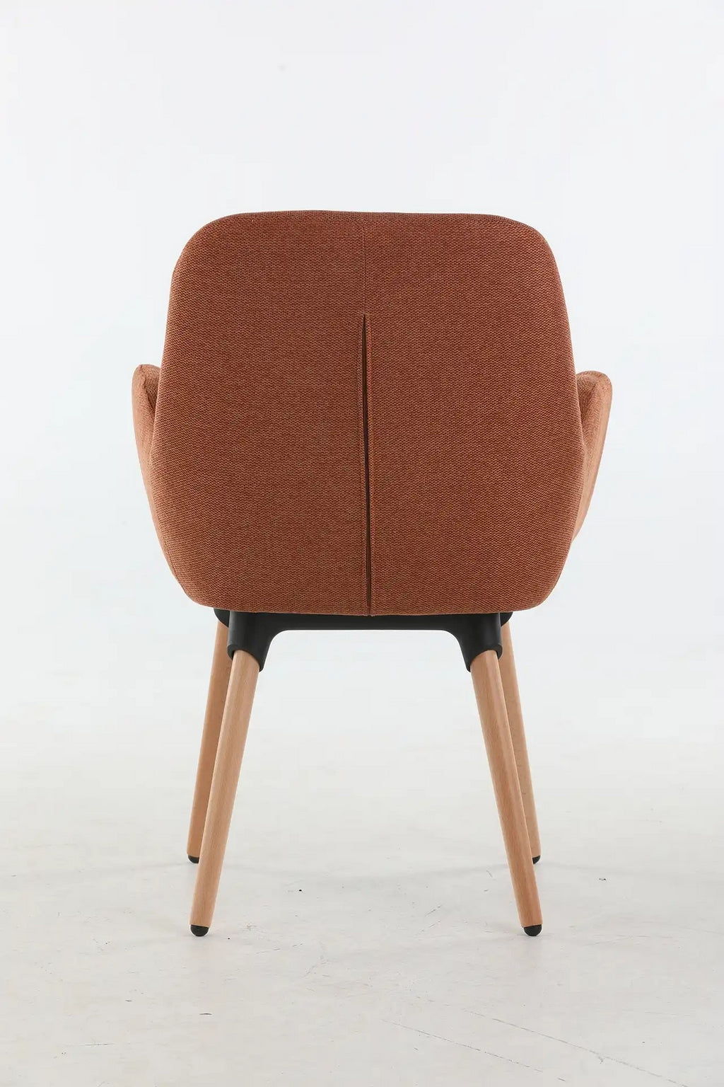 Le Fauteuil d'accueil et réunion Shino de Monsieur Bureau est composé d'un dossier et d'une assise rembourrés de couleur rouille, de pieds en bois clair, d'une structure de support noire et d'accoudoirs, présentés de dos sur un fond blanc uni.