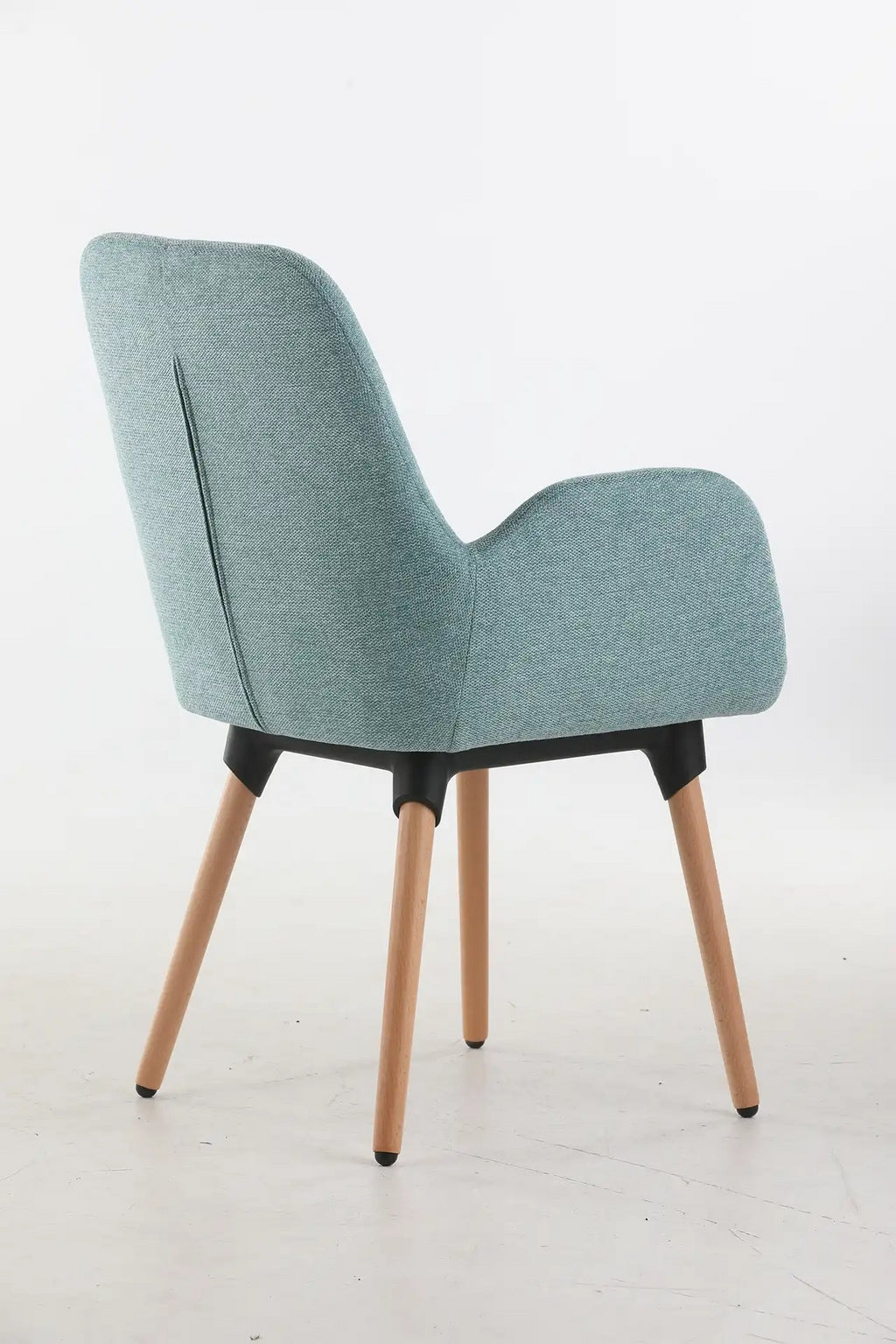 Le Fauteuil d'accueil et réunion Shino de Monsieur Bureau est composé d'une assise rembourrée bleu clair, d'un dossier incurvé et de pieds en bois, présentés sous un angle arrière sur un fond blanc uni.