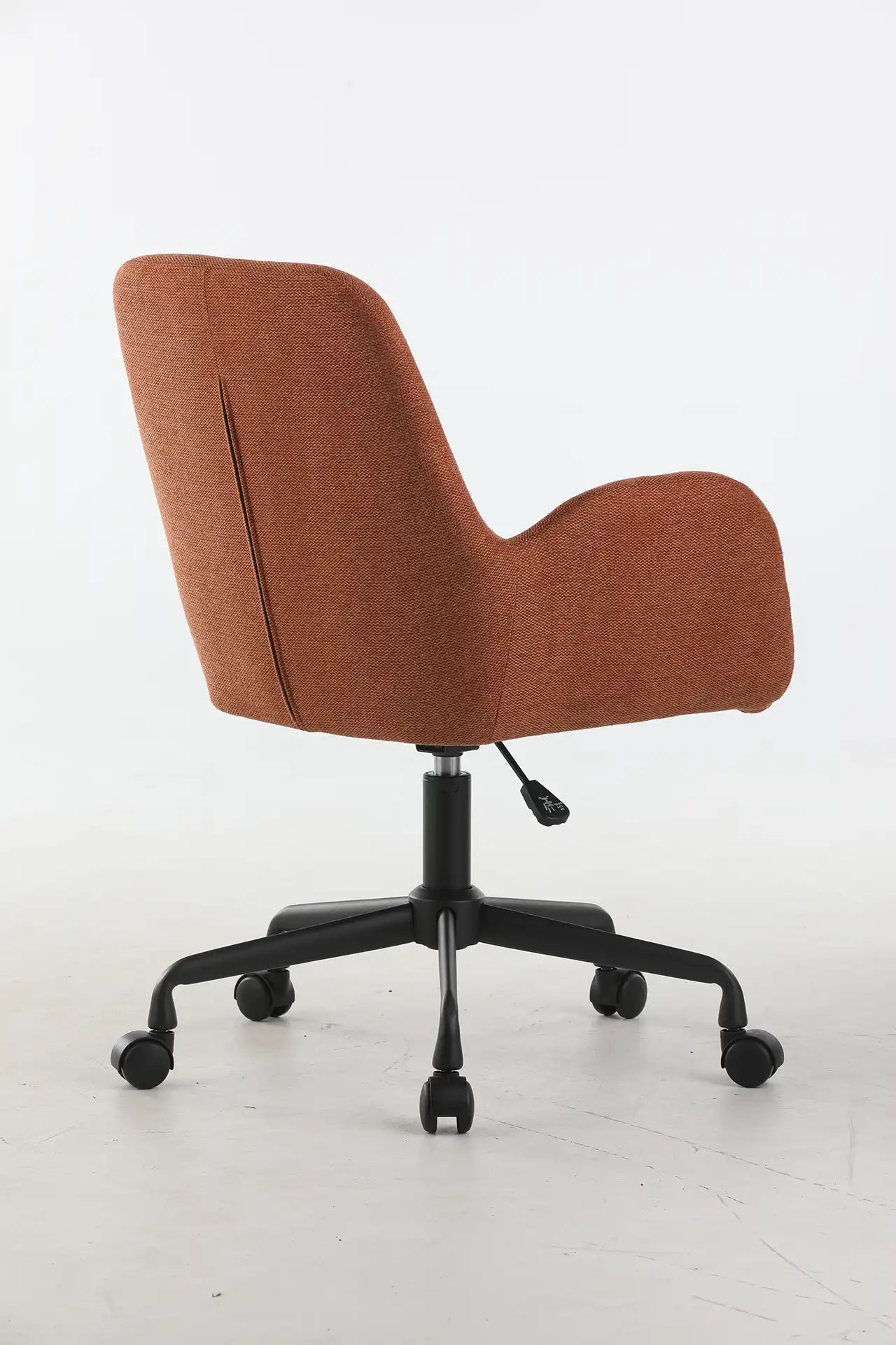 Le Fauteuil d'accueil et réunion Shino - Sur Roulettes de Monsieur Bureau, avec un revêtement rouille, un dossier incurvé et une base noire à cinq roues, est présenté de dos sur un fond blanc uni.