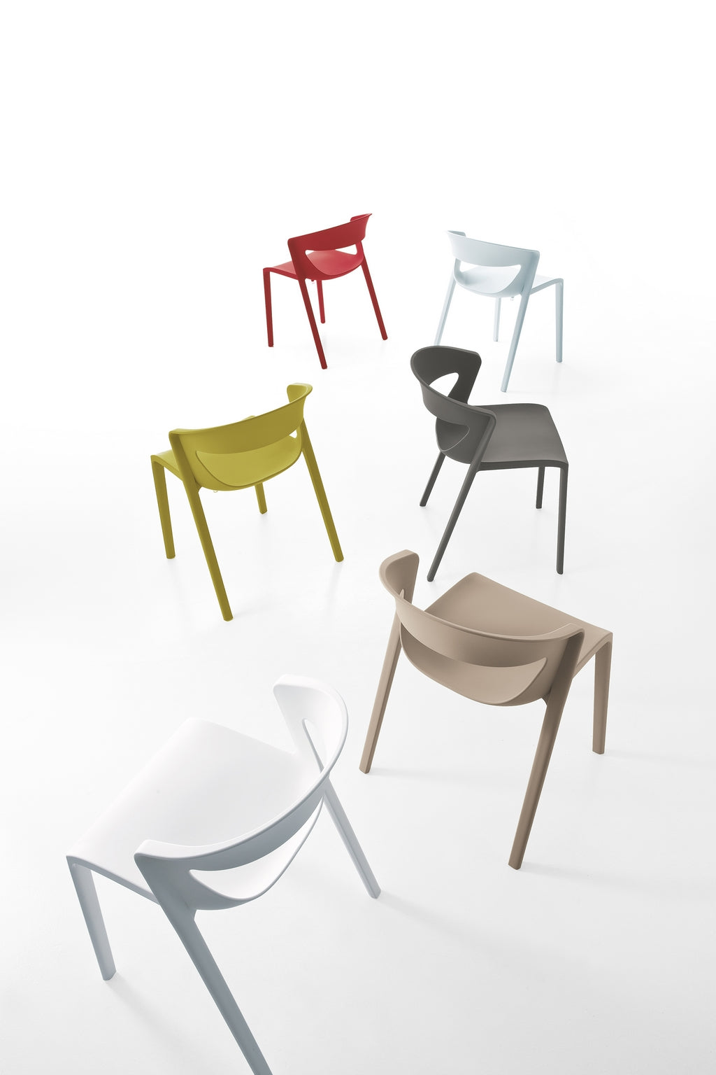 Six chaises Kika de Monsieur Bureau en polypropylène, issues de lots de 2 chaises monobloc empilables, sont disposées façon éclatée sur fond blanc ; leur design moderne les rend idéales pour les collectivités.