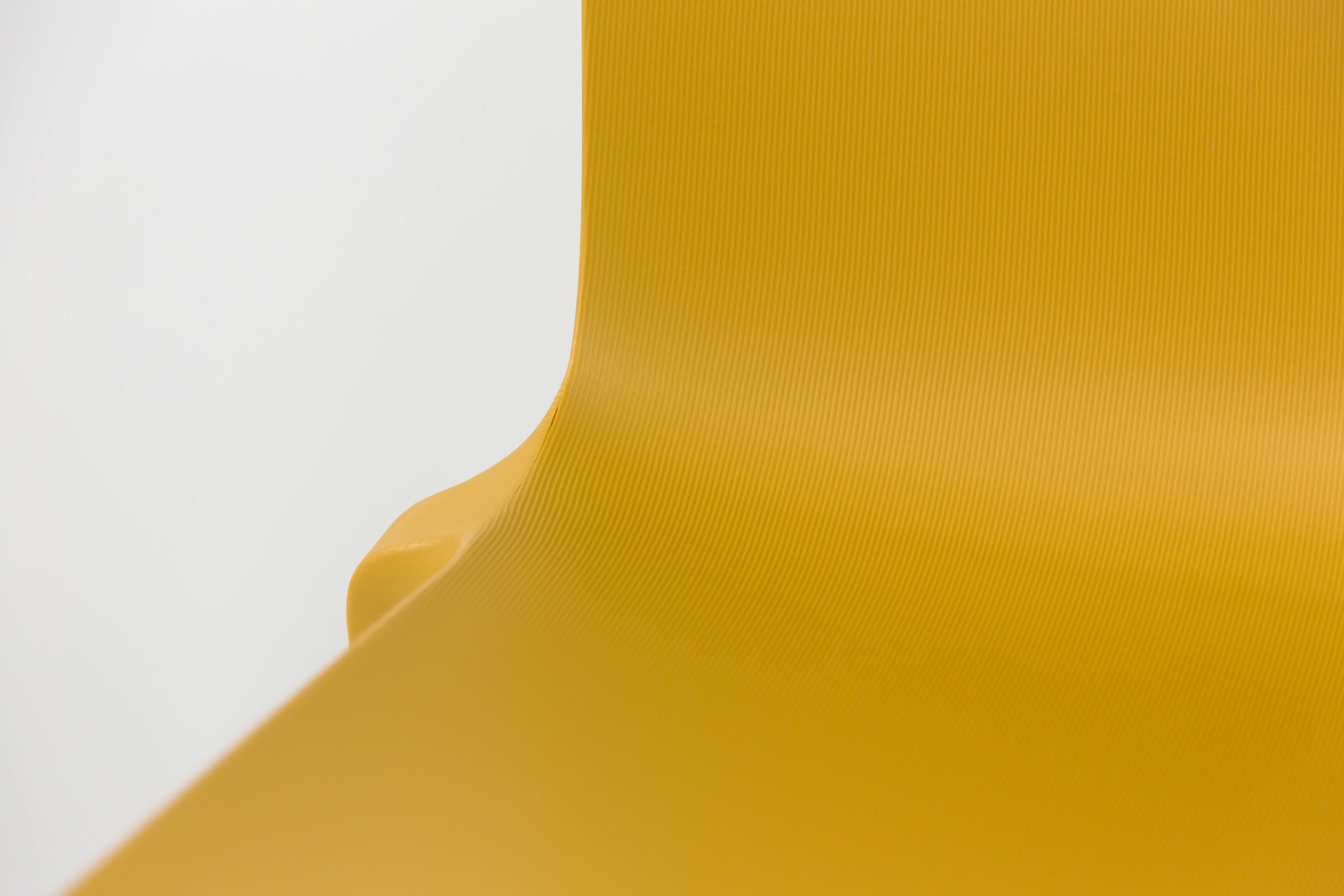 Gros plan sur la Chaise Extérieur Indi Bellini Empilable de Monsieur Bureau, jaune et incurvée, fabriquée en polypropylène avec une texture lisse, présentée sur un fond blanc uni. Son design moderne suggère qu'il s'agit d'un siège d'extérieur empilable.