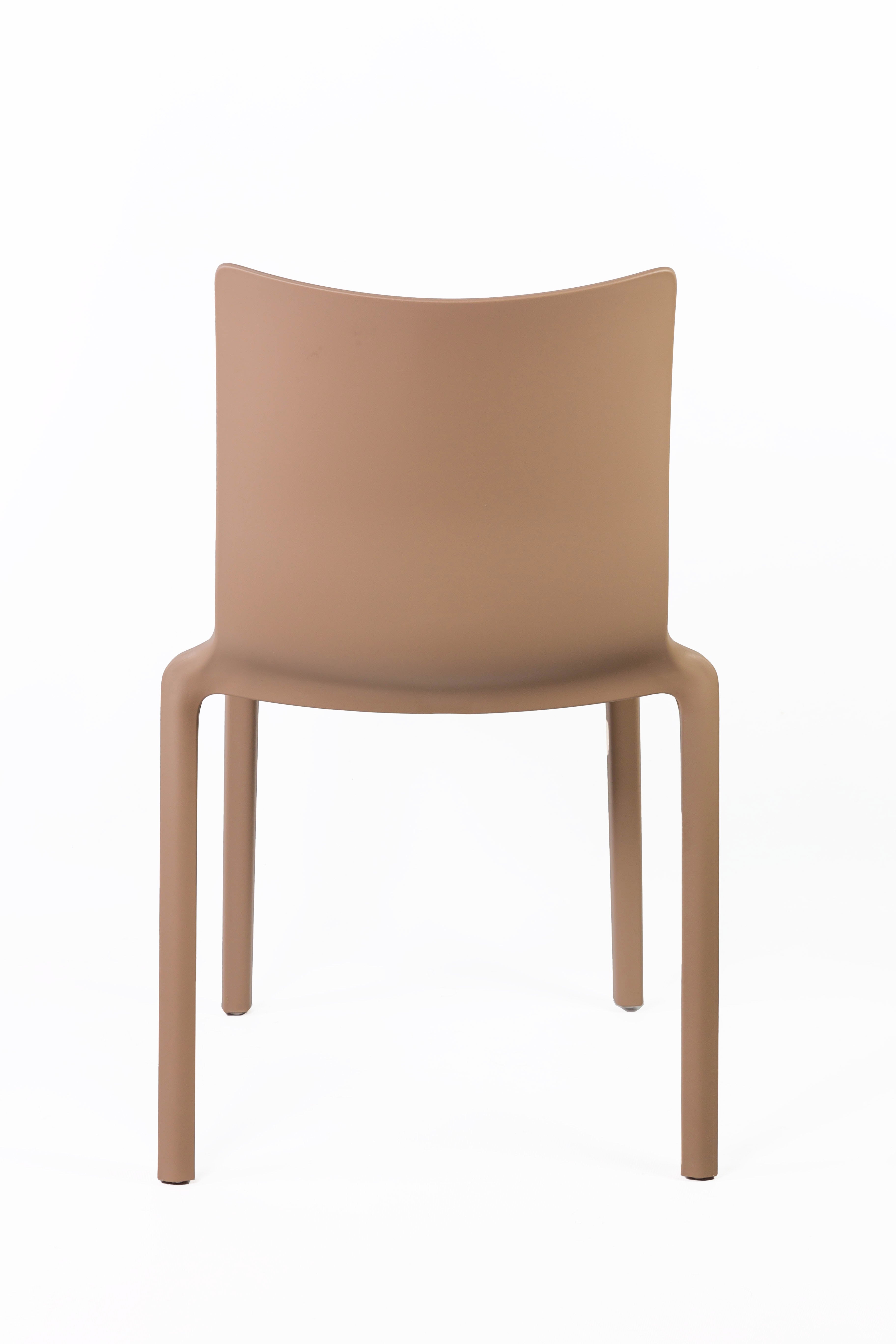 La Chaise Extérieur Indi Bellini Empilable de Monsieur Bureau est une chaise moderne et empilable en polypropylène marron clair avec un dossier solide et quatre pieds droits, présentée sur un fond blanc uni pour un rangement efficace.