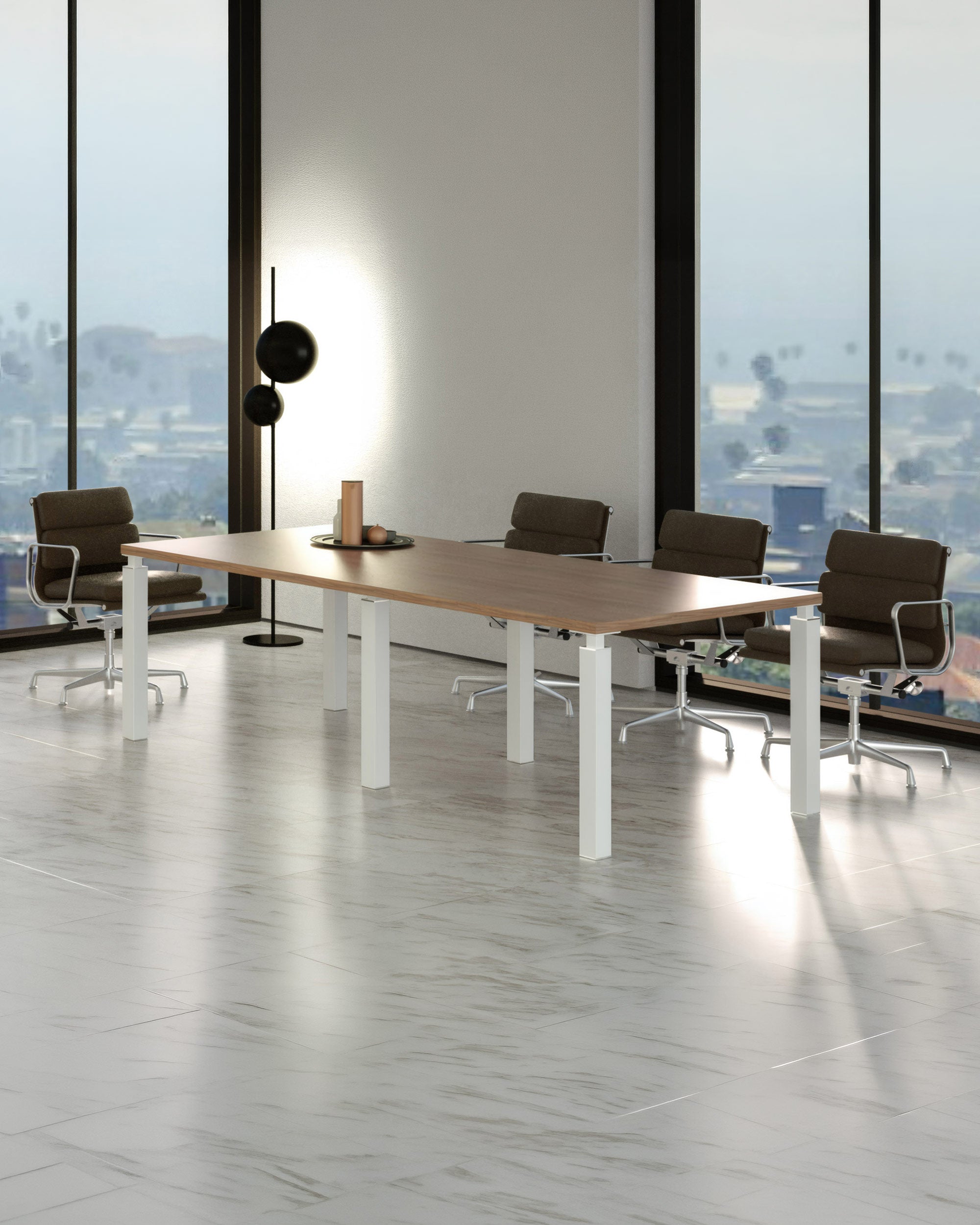 Une salle de conférence moderne avec une Table de Réunion Design Quatro 220 x 100 cm de Monsieur Bureau, quatre chaises de bureau brunes à roulettes, un lampadaire et des fenêtres offrant une vue sur la ville. Le sol carrelé gris clair met en valeur le mobilier de bureau contemporain.#combo_noyer_blanc