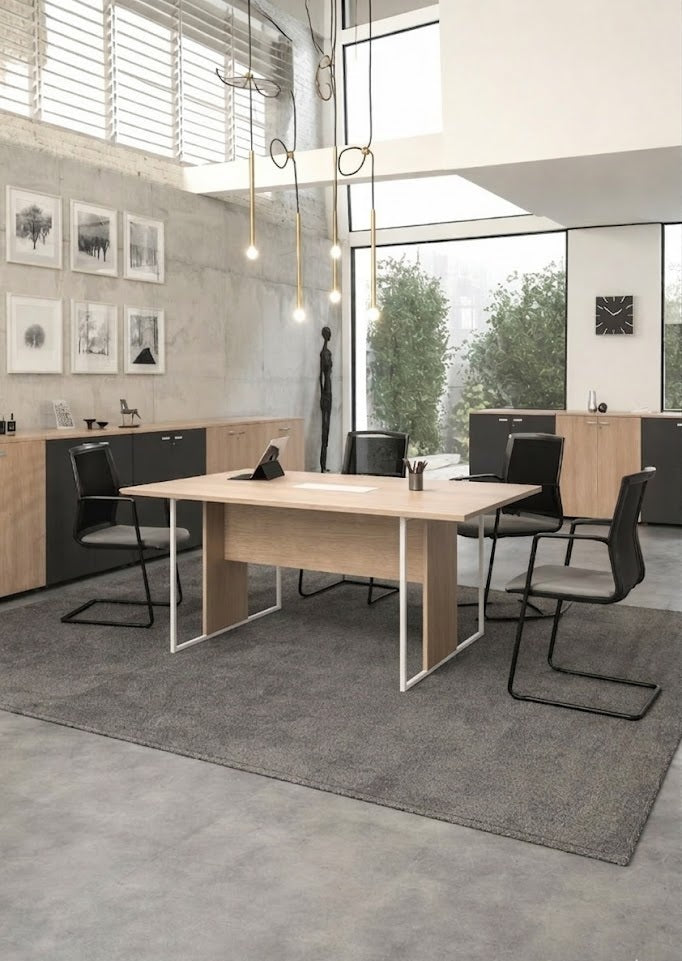 Bureau moderne comprenant la table de réunion professionnelle Monsieur Bureau Edge avec un design italien et un cadre en métal, quatre chaises noires, un tapis gris, un éclairage minimaliste, de grandes fenêtres avec une vue sur les arbres, des armoires murales sous des œuvres d'art et une horloge..#combo_chene_blanc_mat