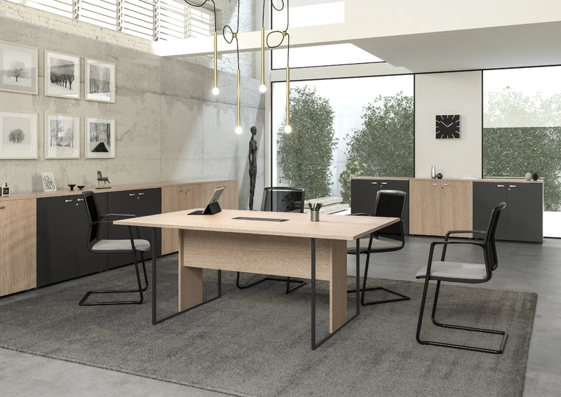 Bureau moderne avec Monsieur Bureau Table de réunion professionnelle Edge (design italien, structure métallique), quatre chaises noires, un tapis gris et des armoires. De grandes fenêtres apportent la lumière naturelle ; décor minimaliste avec des lampes suspendues, des œuvres d'art encadrées, une horloge murale. Arbres à l'extérieur.