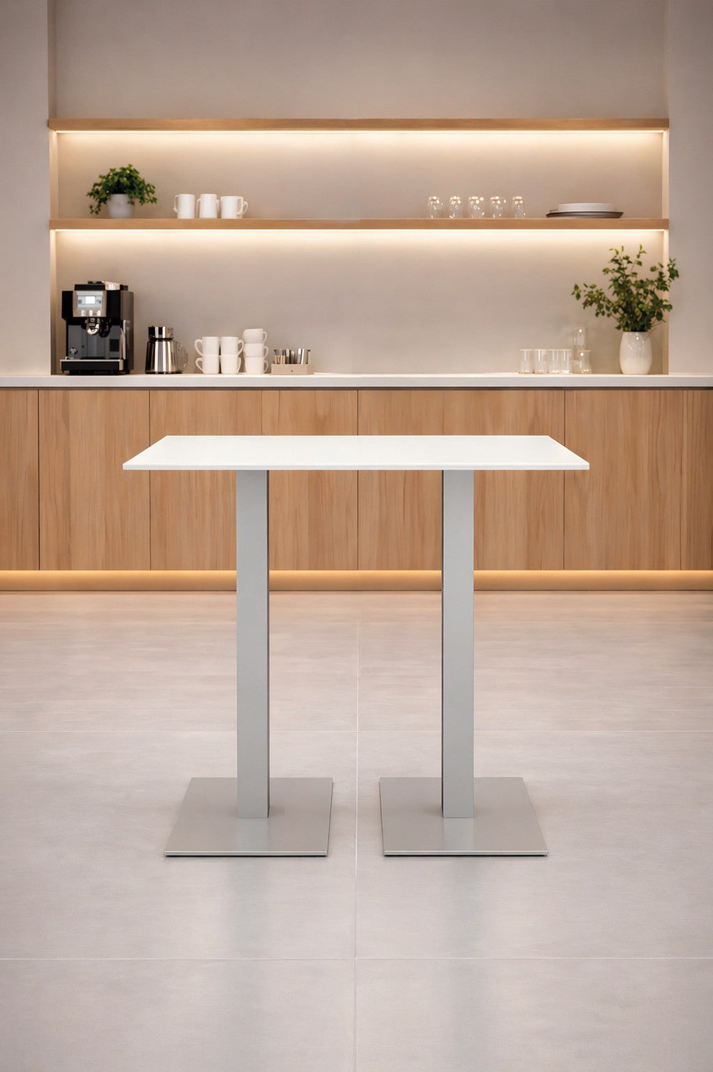 Une cuisine moderne et minimaliste présente le Monsieur Bureau Table haute Newline rectangulaire - Pieds carrés avec deux pieds en métal, des armoires en bois, des étagères ouvertes contenant des tasses et des verres, une machine à café et un éclairage doux.