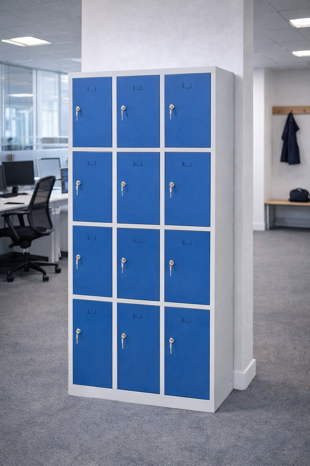 Le Vestiaire métallique Talos 4 portes (1 à 3 colonnes) de Monsieur Bureau, dans un ensemble de douze avec des serrures en argent, se trouve dans un bureau moderne avec des bureaux, des chaises et un manteau sur un banc en bois à proximité.