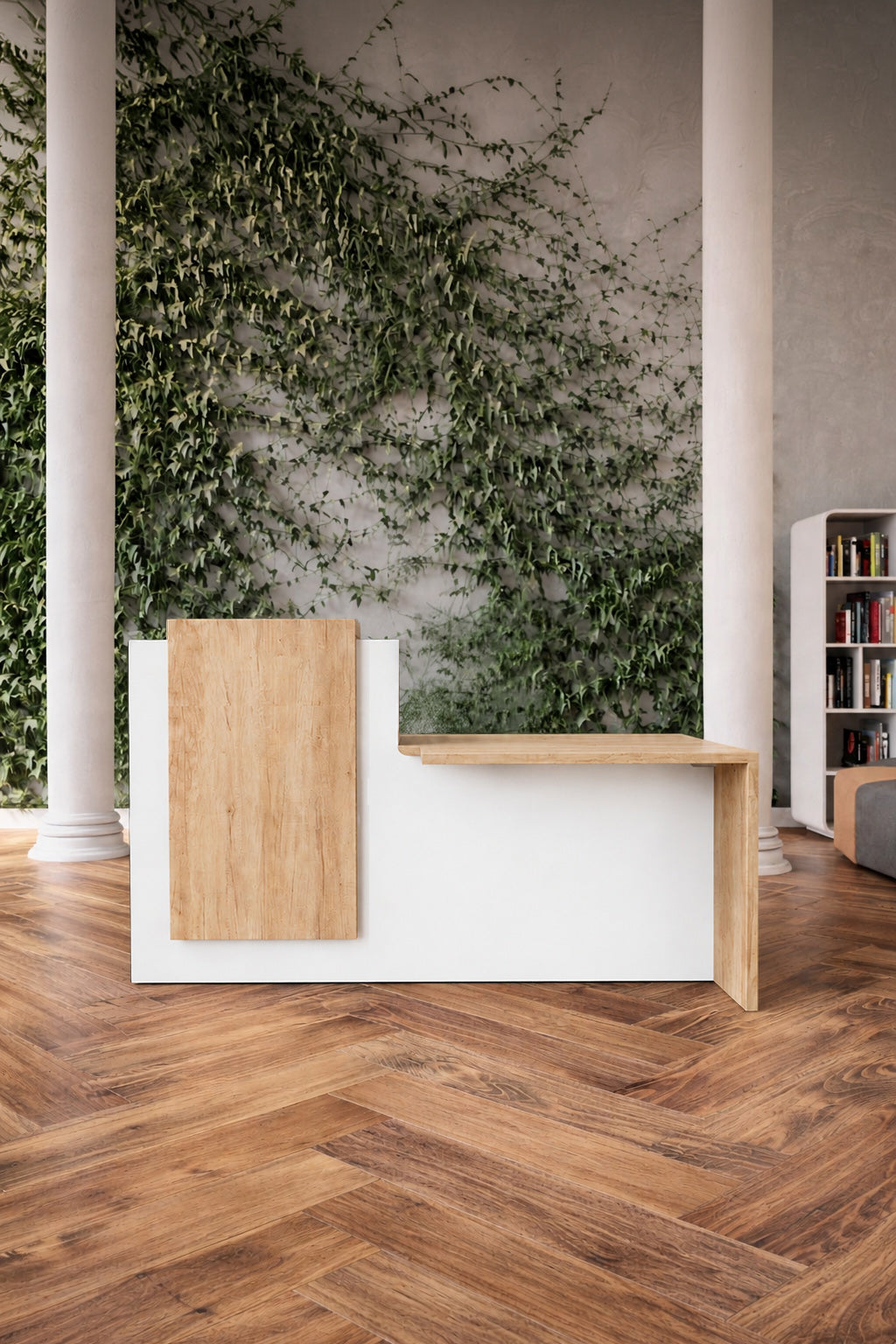 Un intérieur moderne présente la Banque d'accueil Half avec accueil PMR de Monsieur Bureau - un bureau d'accueil minimal en blanc et en bois - posé sur un sol en bois à chevrons, avec de hautes colonnes blanches, un mur de lierre vert et une étagère partiellement visible sur la droite.#combo_plateau+parementchenenebraska_blanc_a_gauche