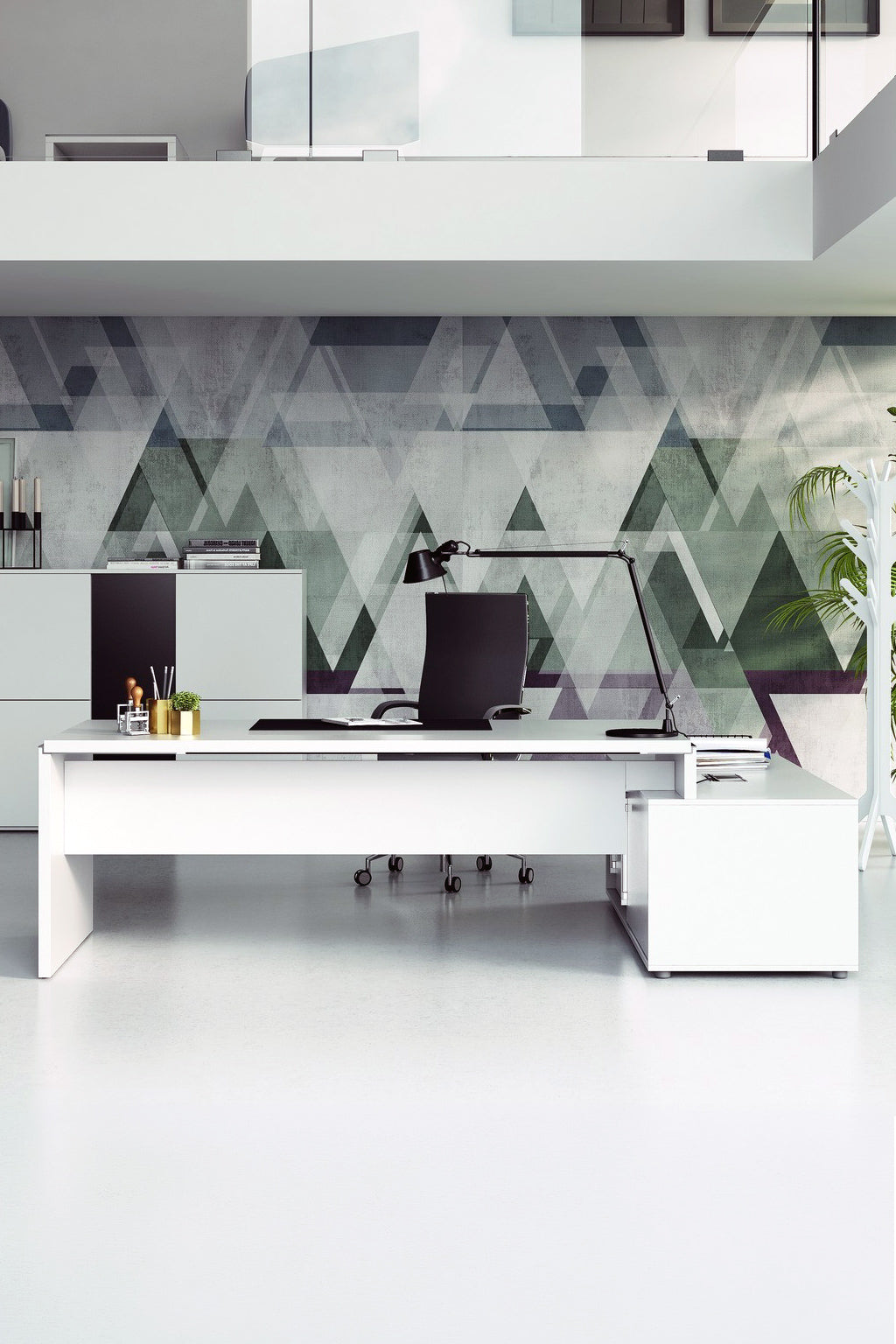 Un bureau moderne avec un grand Bureau de direction Asset avec retour sur crédence de Monsieur Bureau, deux moniteurs noirs, une lampe de bureau noire, des fournitures de bureau et un tableau mural géométrique vert-gris. Un mobilier minimaliste dans un espace clair et épuré.#combo_retour_a_gauche_blanc