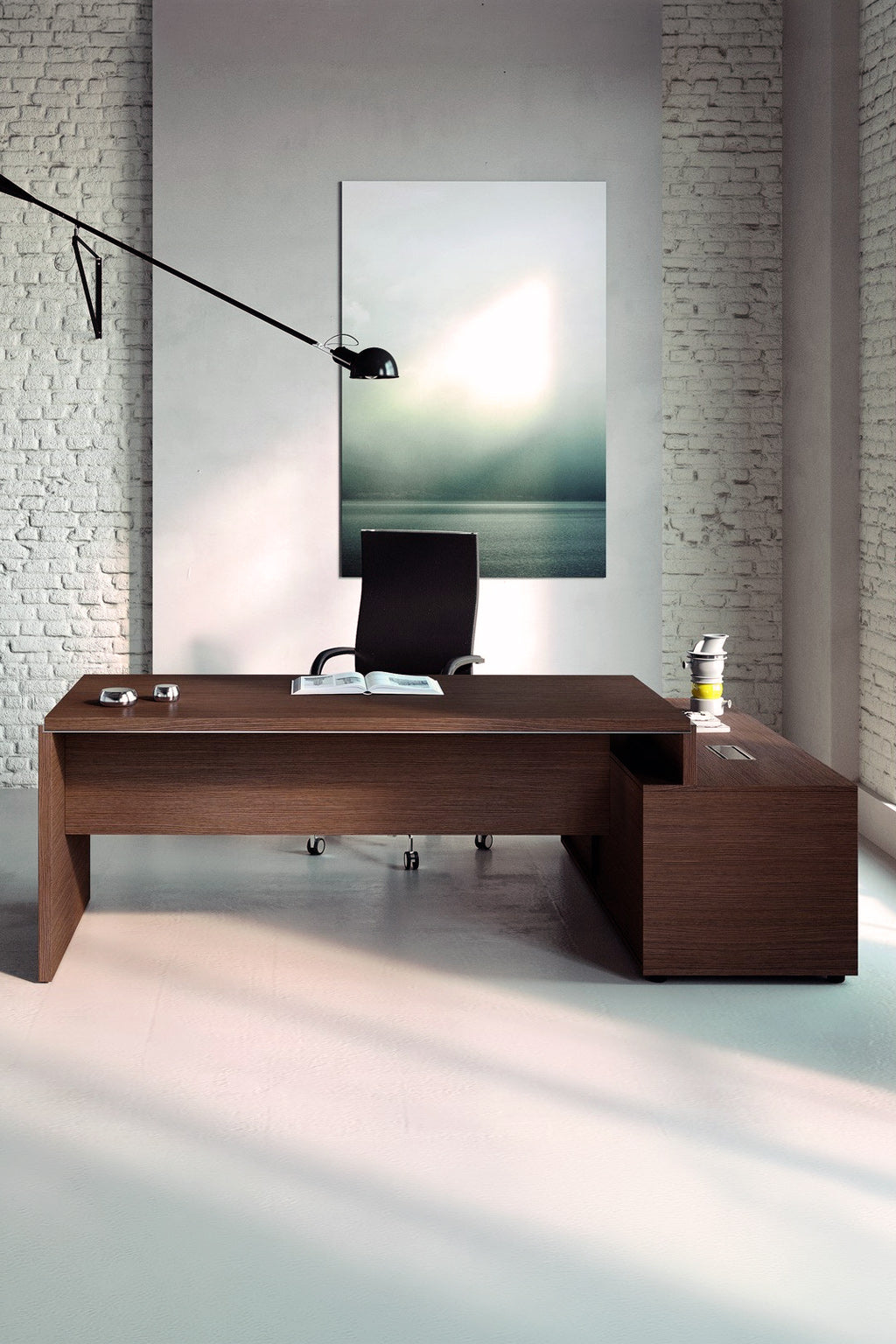 Le Bureau de direction Asset avec retour sur crédence de Monsieur Bureau se compose d'un bureau spacieux en bois, d'une chaise pivotante noire, d'un décor minimal et d'une photo de mer brumeuse. Les murs en briques blanches et l'éclairage doux créent un espace de travail italien élégant.#combo_retour_a_gauche_noyer