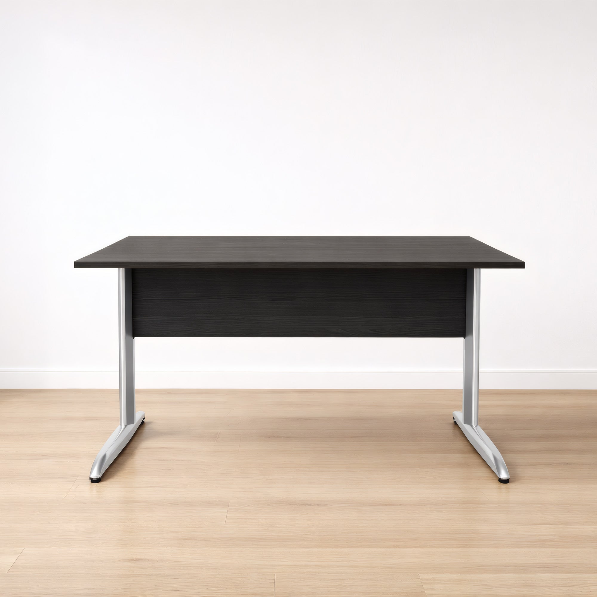 Le Monsieur Bureau Pro Effect Droit ou Angle Modulable se caractérise par un plateau en bois foncé, des pieds en métal argenté et un voile de fond. Il est présenté sur un sol en bois clair contre un mur blanc uni.#combo_frene_noir_chrome_bureau