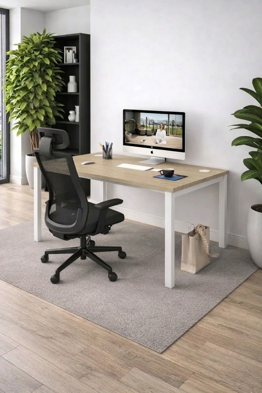 Un espace de travail moderne met en valeur le Bureau individuel Astral Profondeur 70 ou 80 de Monsieur Bureau, associé à une chaise ergonomique sur un tapis gris. La pièce lumineuse et minimale est complétée par des plantes et une étagère noire remplie de livres.#combo_chene_fil_blanc