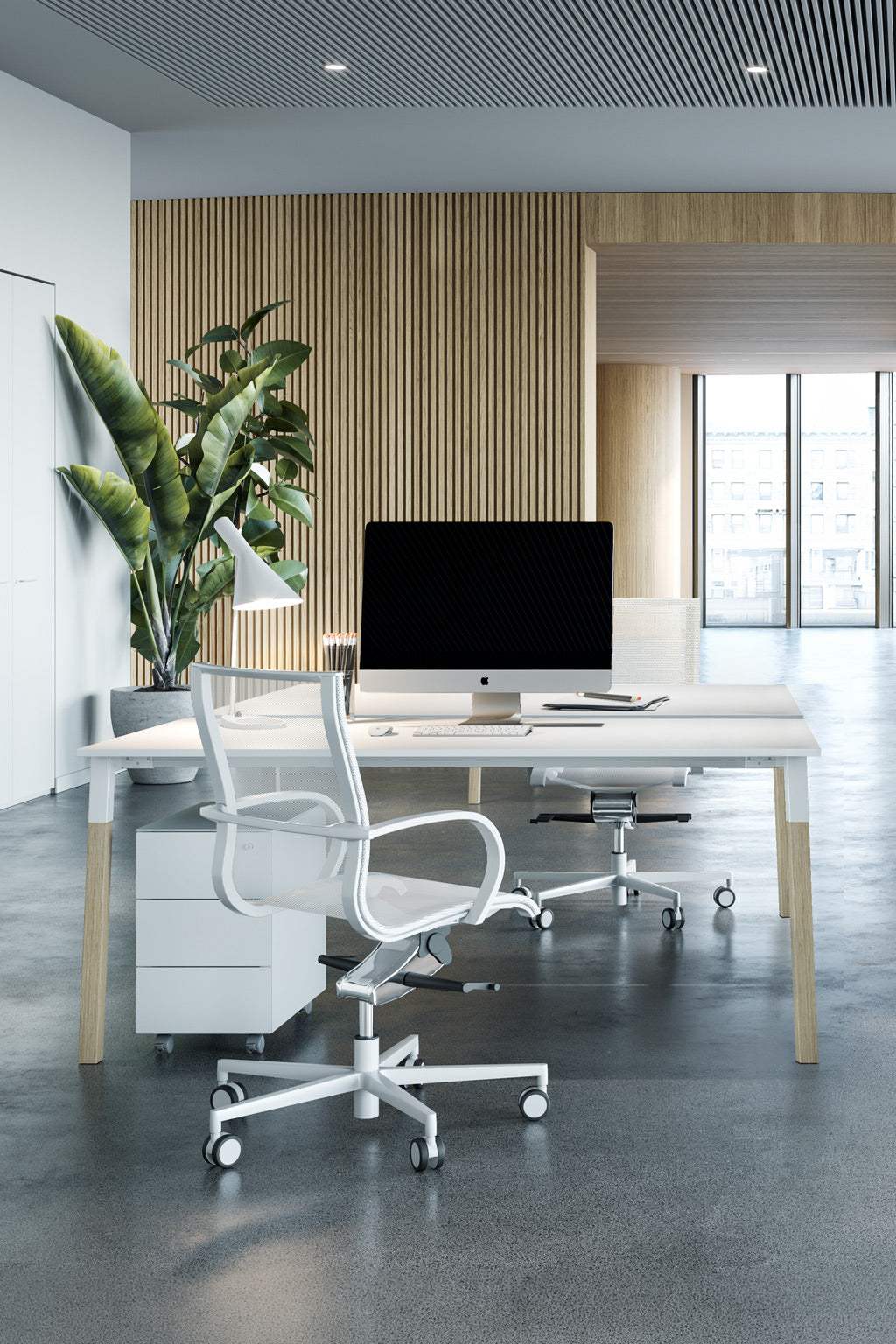 Un bureau moderne en open space avec la double station de travail Bureau bench POP WOODY de Monsieur Bureau, avec un bureau blanc élégant, un écran, une chaise roulante, une plante en pot, un mur en panneaux de bois et de grandes fenêtres pour la lumière naturelle - idéal pour le travail d'équipe.