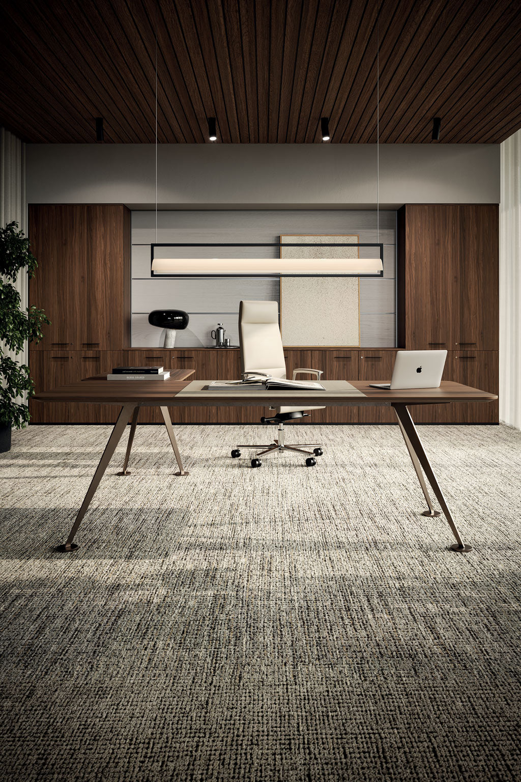 Le bureau de direction Monsieur Bureau Spike en placage bois avec retour est associé à une chaise de bureau beige, un ordinateur portable et des livres. Des armoires en bois et des œuvres d'art tapissent le mur du fond, tandis qu'un grand plafonnier illumine la moquette texturée.