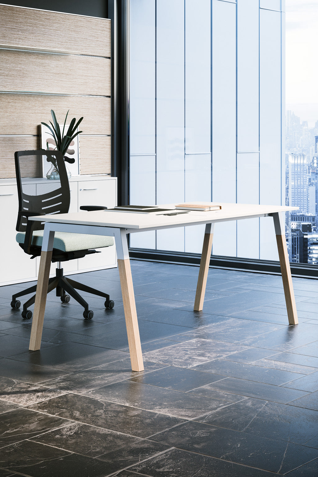Le Bureau individuel POP WOODY de Monsieur Bureau est un bureau moderne avec un plateau blanc et des pieds en bois, associé à une chaise pivotante en maille noire et à une plante en pot, le tout placé près d'une grande fenêtre donnant sur les grands immeubles de la ville.