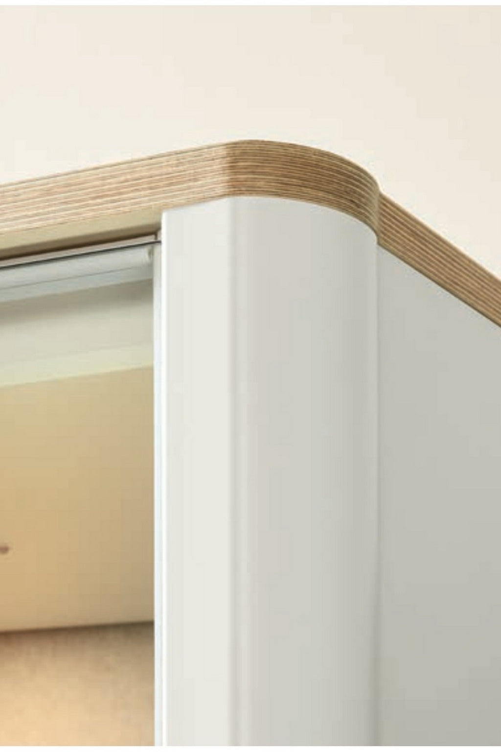 Gros plan sur l'angle d'une cabine Monsieur Bureau Cabine acoustique Silen - Phone booth 1 personne, avec des bords arrondis, des détails en contreplaqué sur le bord supérieur et une porte partiellement ouverte dans cet espace de concentration.