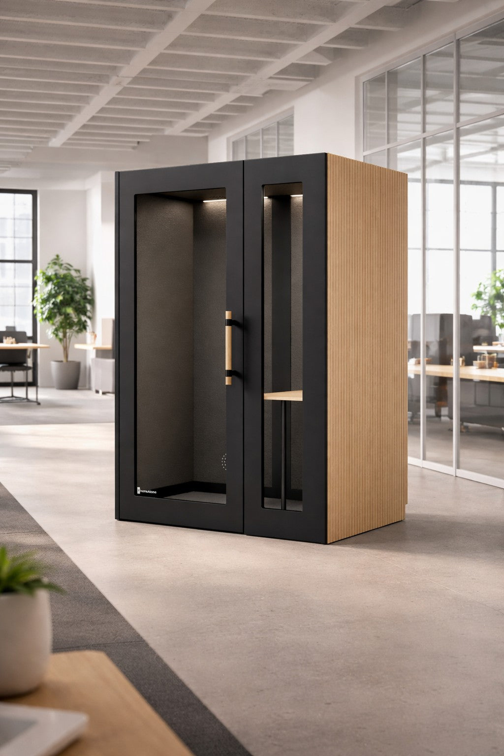 La Cabine acoustique de Travail NO SOUND Executive 1 pers de Monsieur Bureau est dotée d'une porte en verre et de panneaux en bois, offrant une isolation acoustique dans un bureau ouvert et lumineux avec des plantes, des bureaux et de grandes fenêtres.#finitions_noir