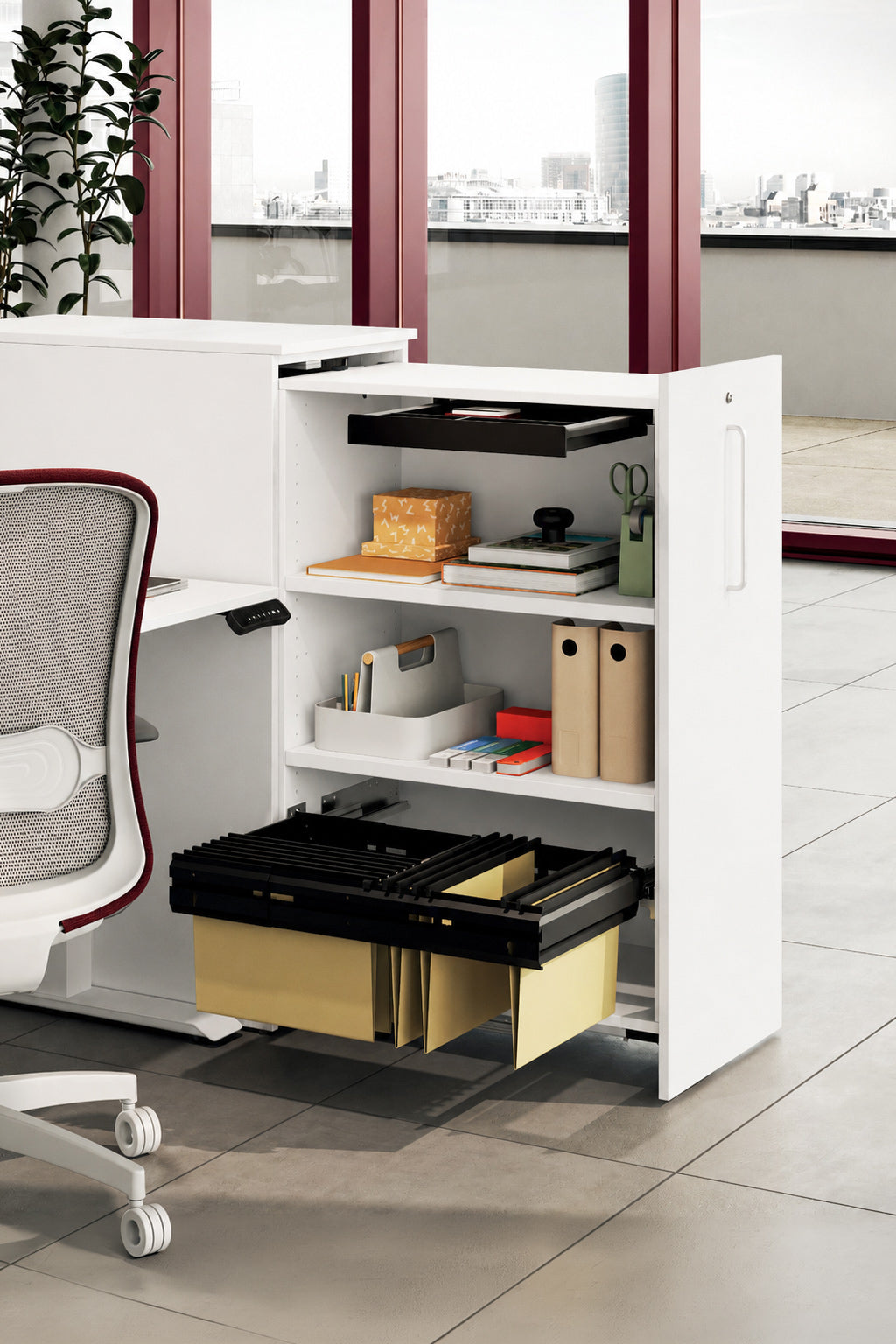 Le Caisson haut ORGATOWER de Monsieur Bureau, compatible avec les bureaux individuels (plateau 18 mm), dispose d'étagères ouvertes et d'un tiroir coulissant pour les dossiers. Il constitue une solution de rangement élégante à côté d'un bureau moderne dans un espace de travail lumineux.