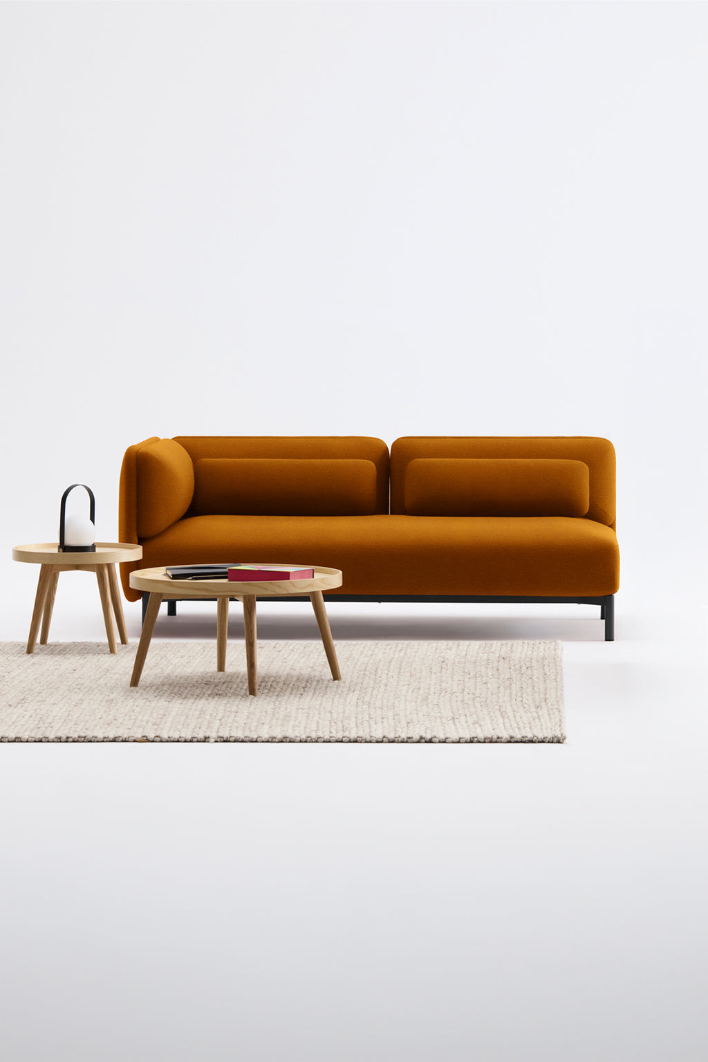 Un salon contemporain avec le Canapé d'accueil modulaire Aurea - 1 accoudoir de Monsieur Bureau - un canapé jaune moutarde, deux tables basses rondes en bois et un tapis à la texture claire sur un fond blanc uni.