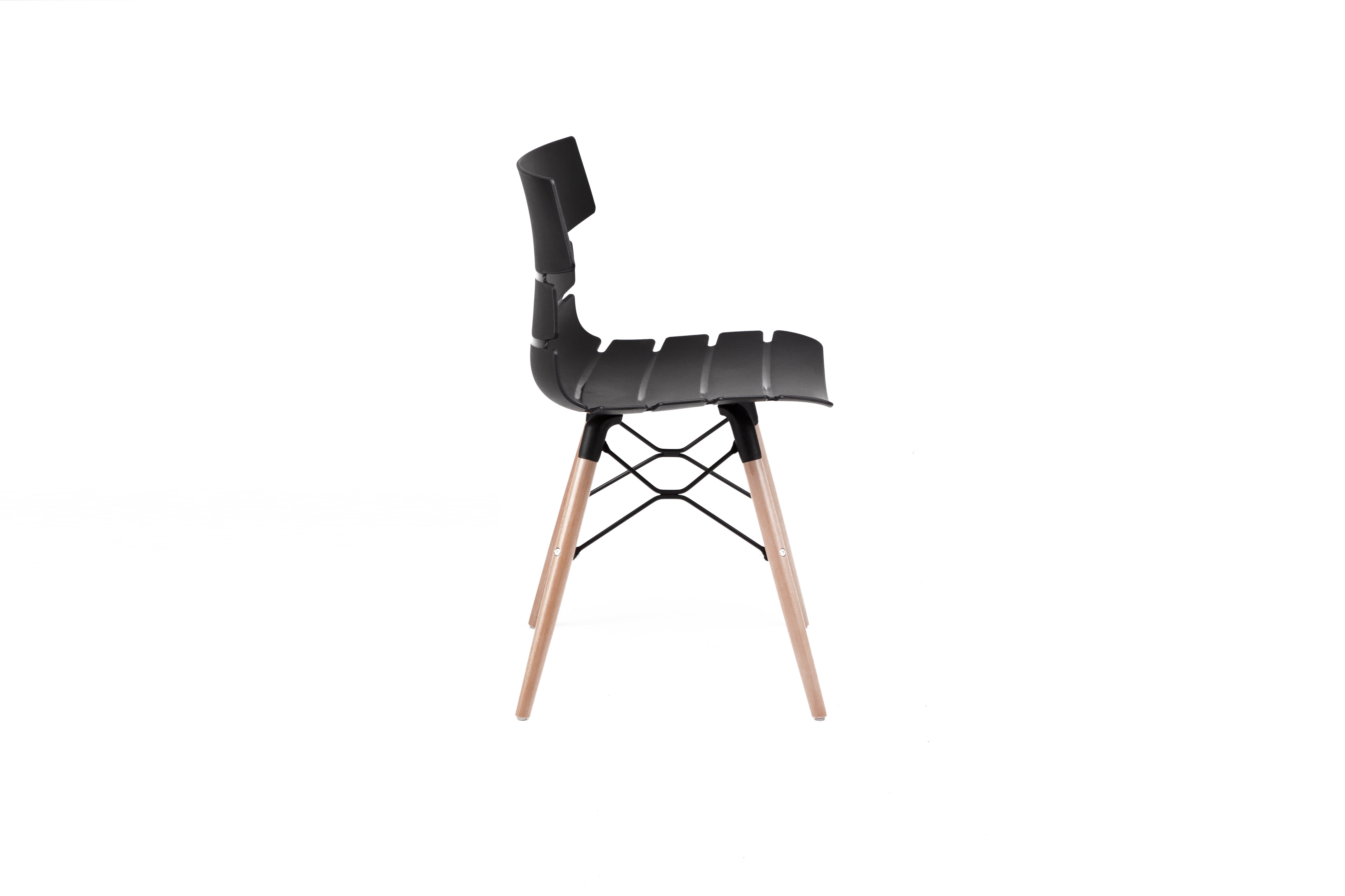 La Chaise Carene Bellini Coque Polypro Pieds Bois de Monsieur Bureau est une chaise de collectivité moderne en polypropylène noir avec un dossier incurvé et des pieds en bois, présentée de profil sur un fond blanc.