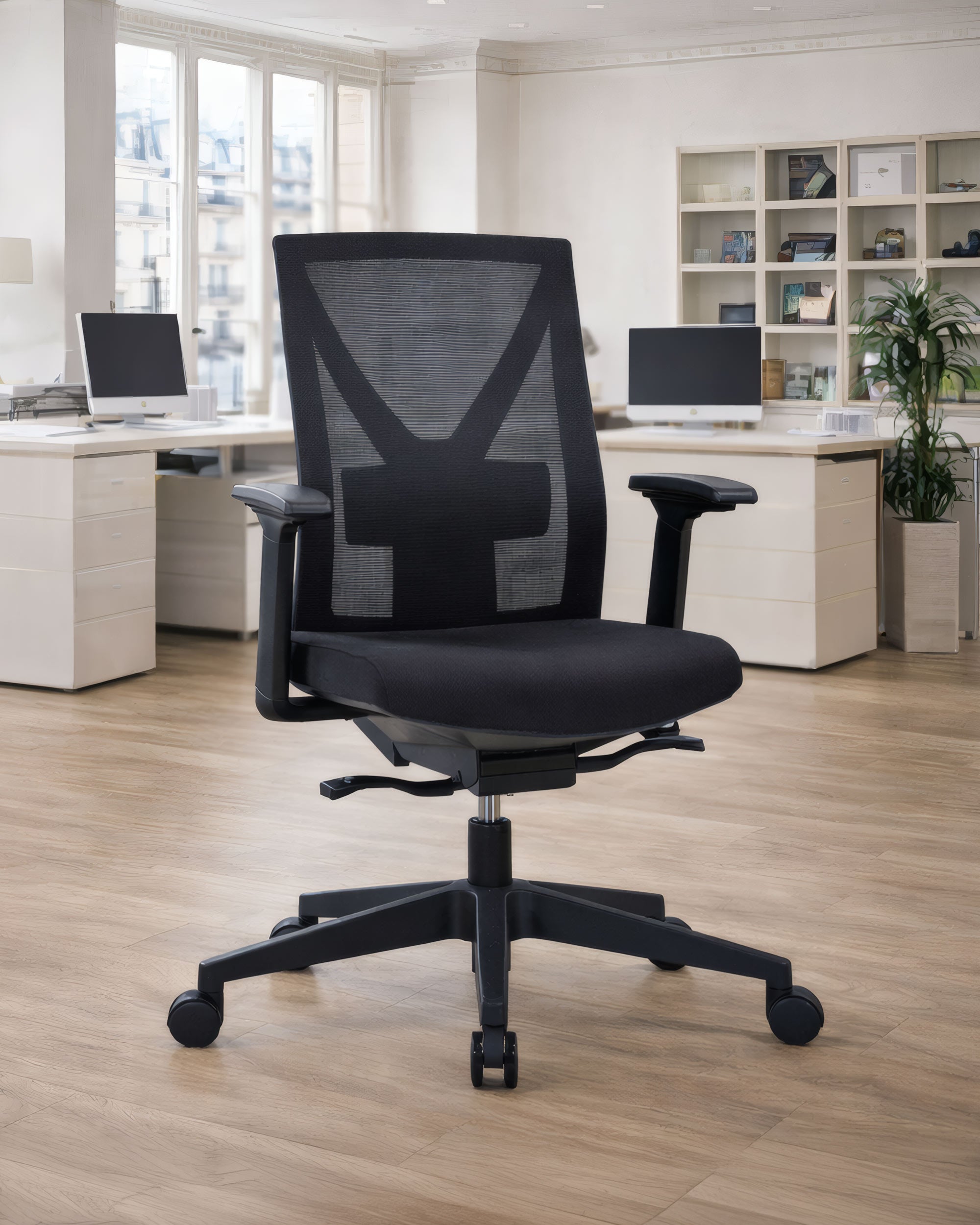 Le Monsieur Bureau Fauteuil Auriga Mécanisme Basculant Décentré, noir, avec dossier en maille et accoudoirs réglables, apporte confort professionnel et style moderne à un bureau lumineux équipé de bureaux, ordinateurs et étagères.