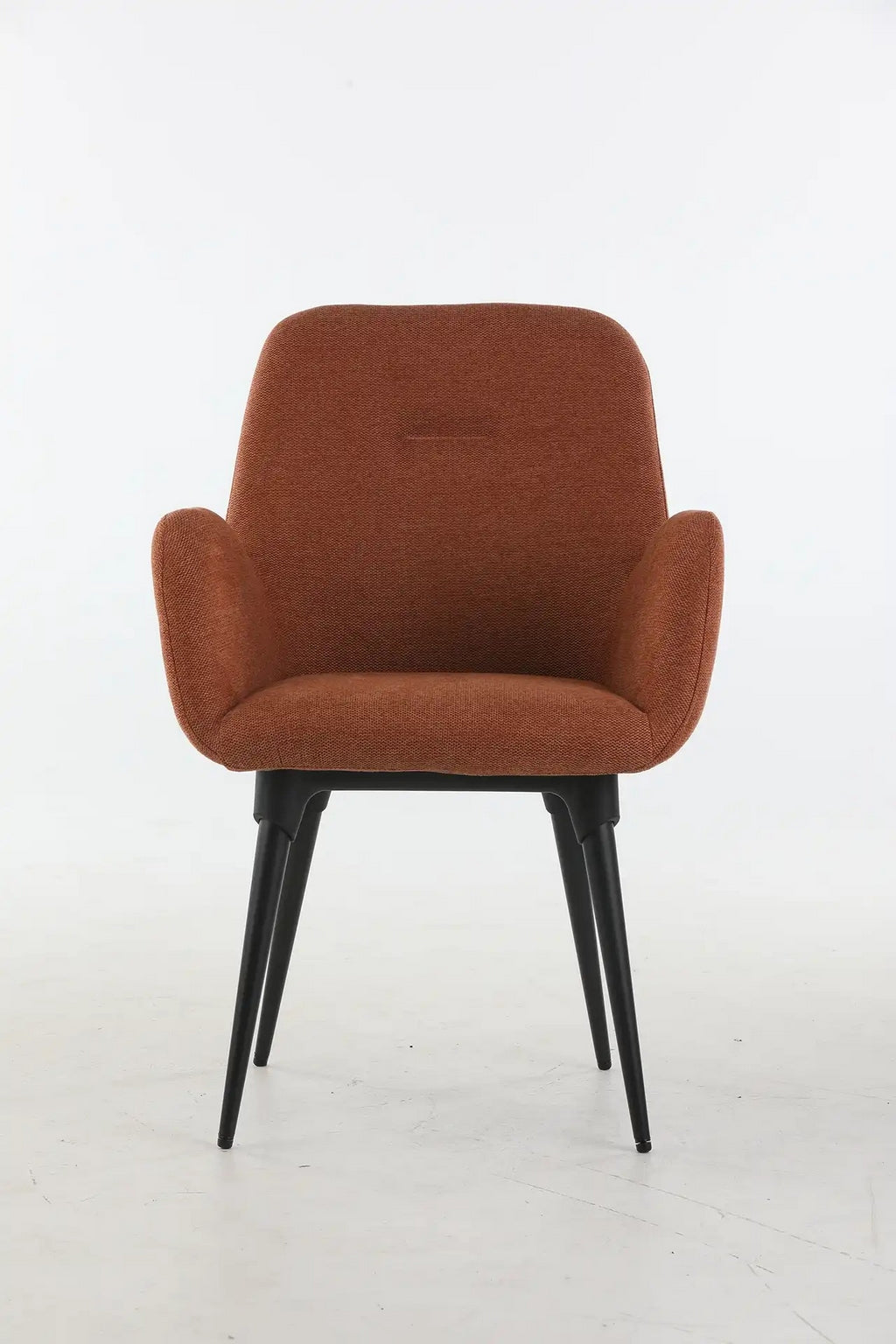 Le Fauteuil d'accueil et réunion Shino de Monsieur Bureau se caractérise par un revêtement de couleur rouille, des accoudoirs incurvés et quatre pieds angulaires en métal noir, présentés sur un fond blanc uni.
