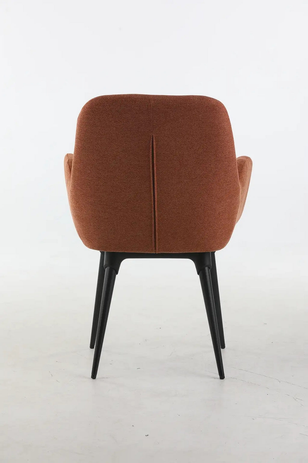 Le Fauteuil d'accueil et réunion Shino - Pieds métal de Monsieur Bureau se caractérise par un dossier et une assise rembourrés de couleur rouille et de minces pieds en métal noir, représentés sur un fond blanc uni.