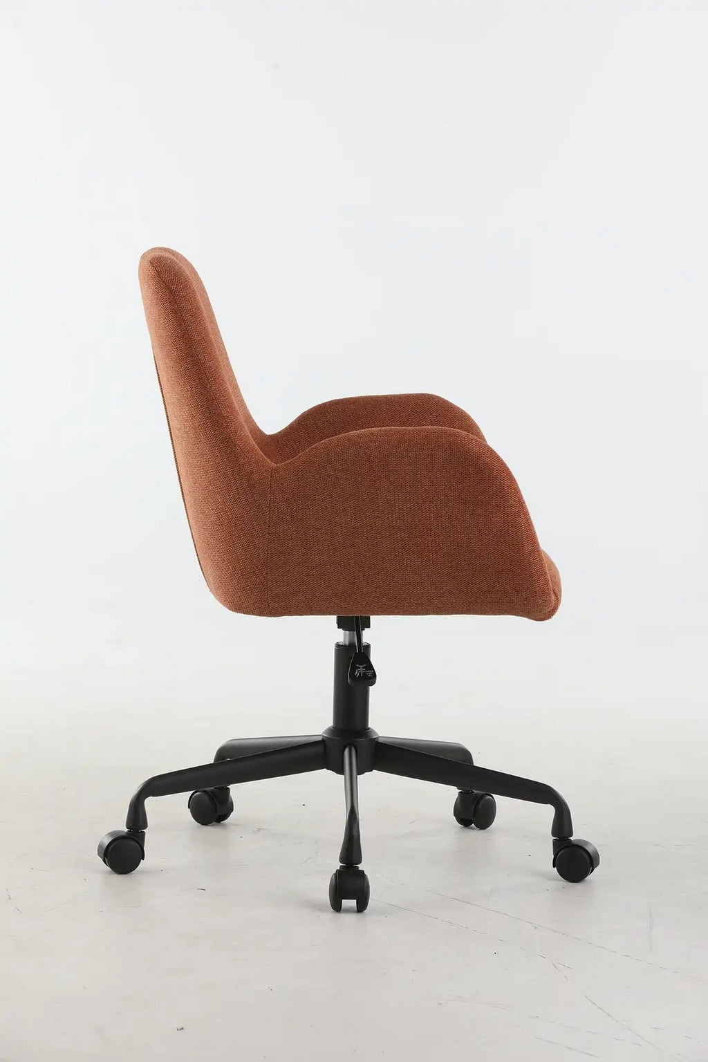 Le Fauteuil d'accueil et réunion Shino - Sur Roulettes de Monsieur Bureau, avec un tissu de couleur rouille et une base pivotante noire à cinq roues, est présenté de profil sur un fond blanc uni.