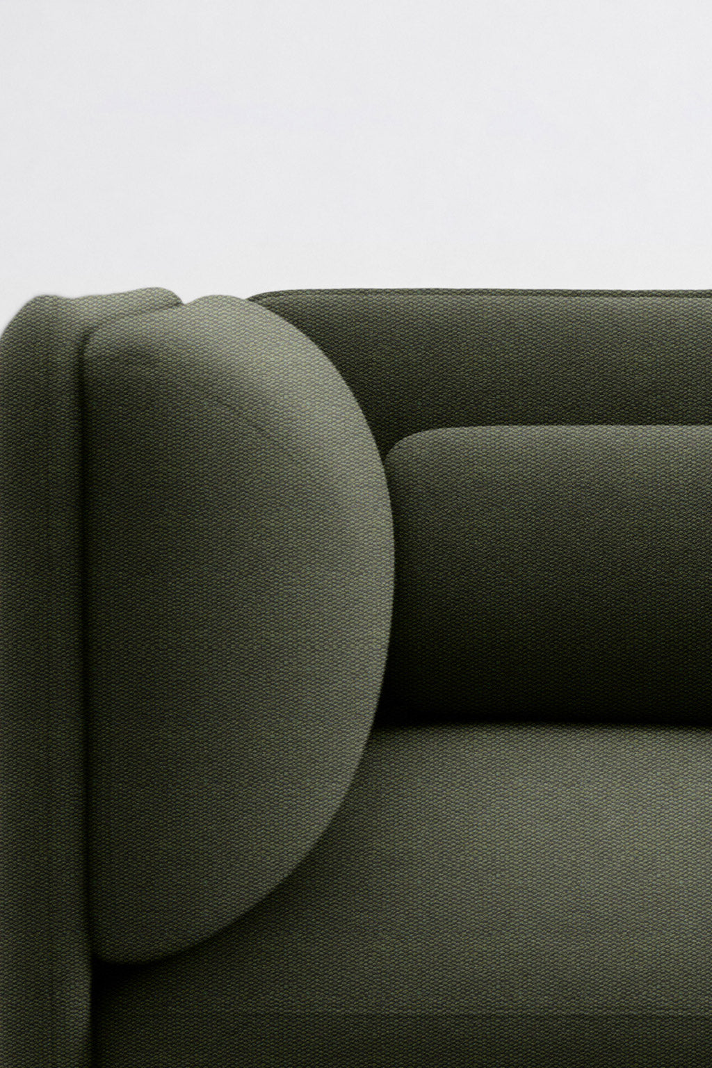 Gros plan sur le Fauteuil d'accueil modulaire Aurea de Monsieur Bureau, doté d'un revêtement moderne vert foncé, d'un dossier et d'un accoudoir arrondis, d'un design géométrique minimaliste, le tout sur un fond clair uni.#finitions_vert528