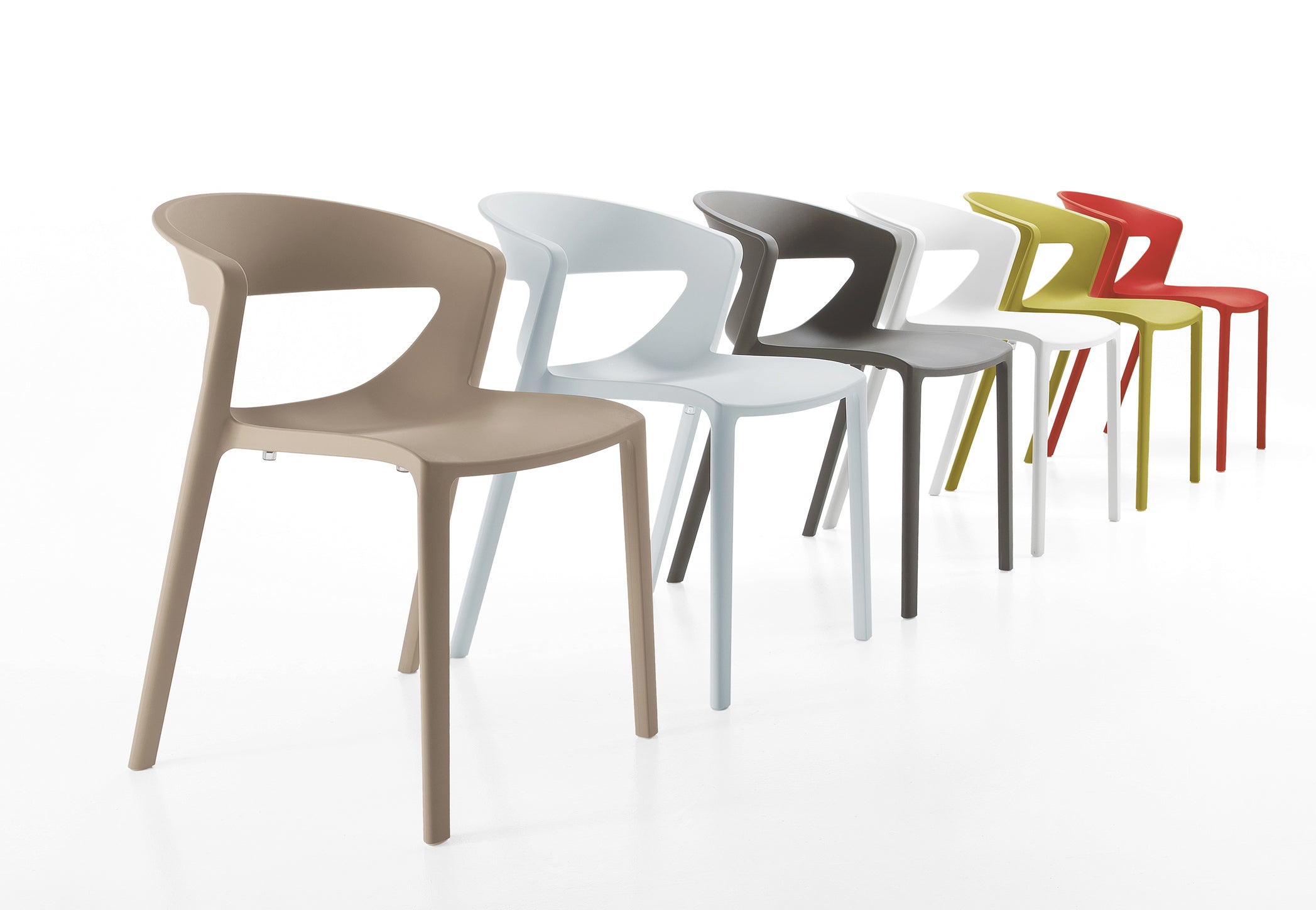 Six chaises monobloc empilables Kika Polypropylène de Monsieur Bureau, aux couleurs variées (beige, bleu clair, gris, blanc, jaune-vert et rouge), sont disposées en diagonale sur fond blanc. Idéales pour le mobilier de collectivité.