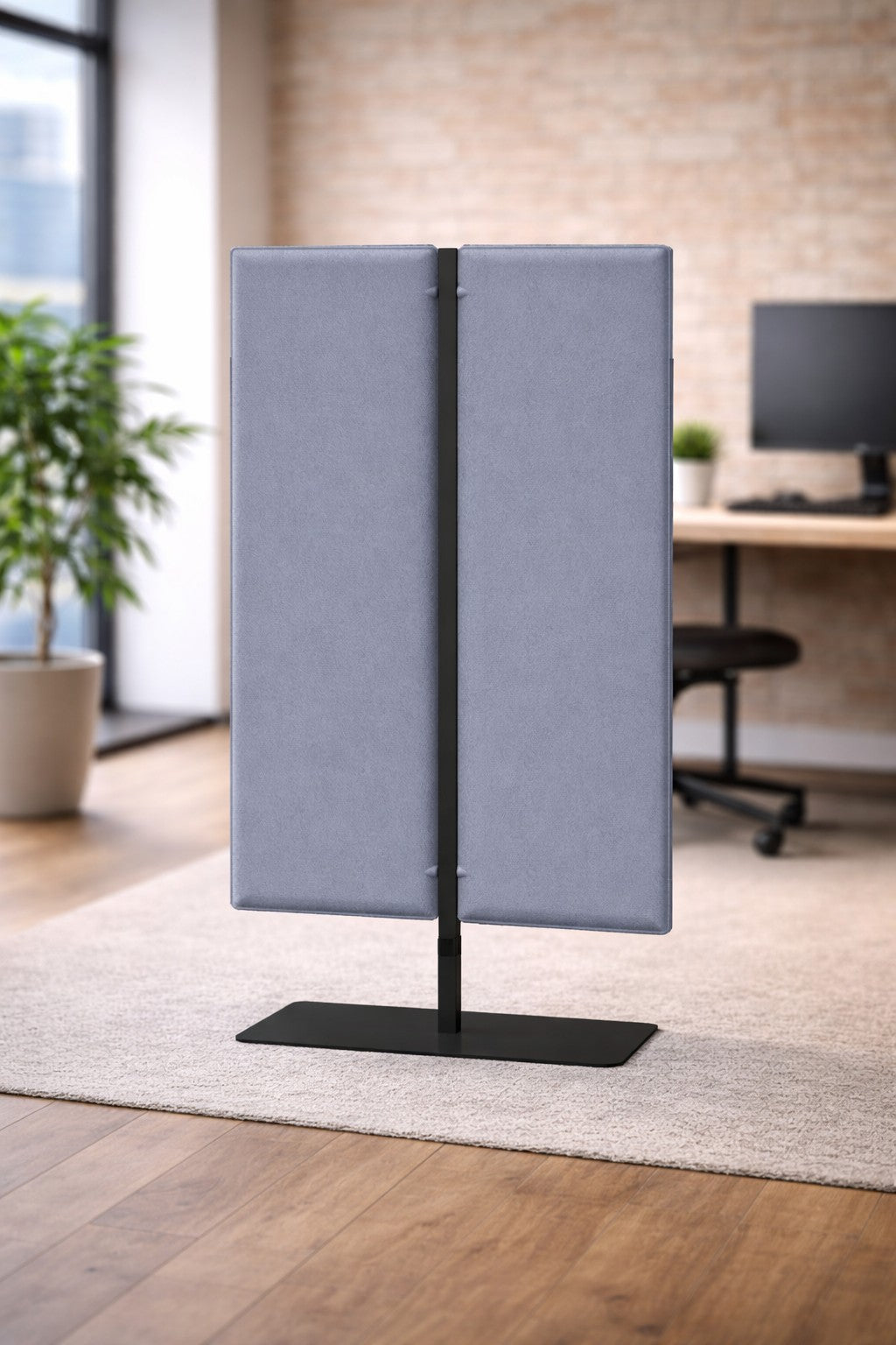 Le Monsieur Bureau Cloison acoustique Aria H140/H160/H180 en gris avec une base noire assure l'intimité et l'isolation phonique dans un bureau moderne avec des planchers en bois, un bureau, une chaise, une plante et de grandes fenêtres.#finitions_beu_azur
