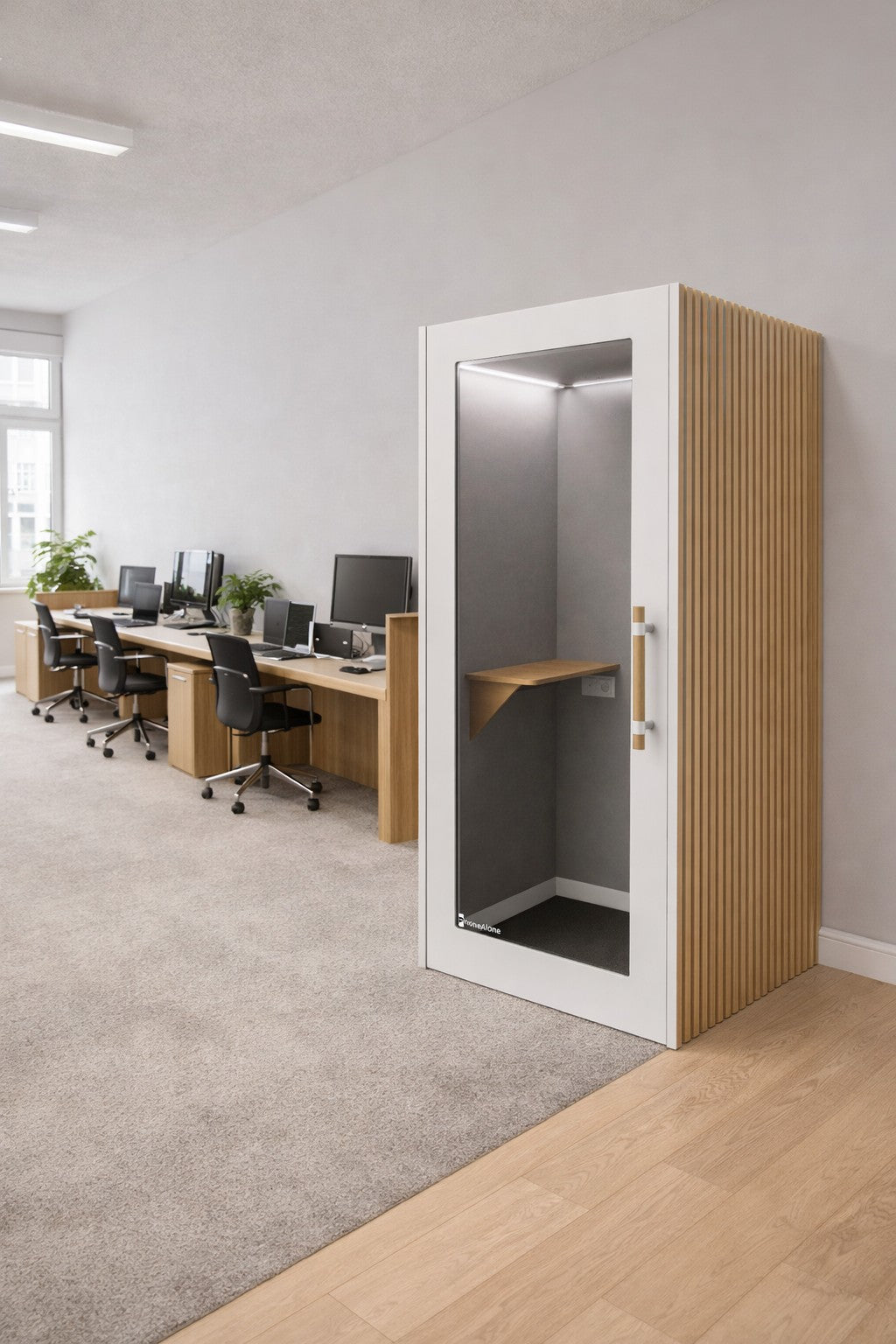 Un bureau ouvert moderne avec des bureaux sur la gauche et une cabine téléphonique Monsieur Bureau acoustique NO SOUND Executive 1 personne - comprenant une porte en verre, un cadre en bois et une étagère - sur la droite, offrant un isolement phonique par l'espace de travail recouvert de moquette.#finitions_blanc