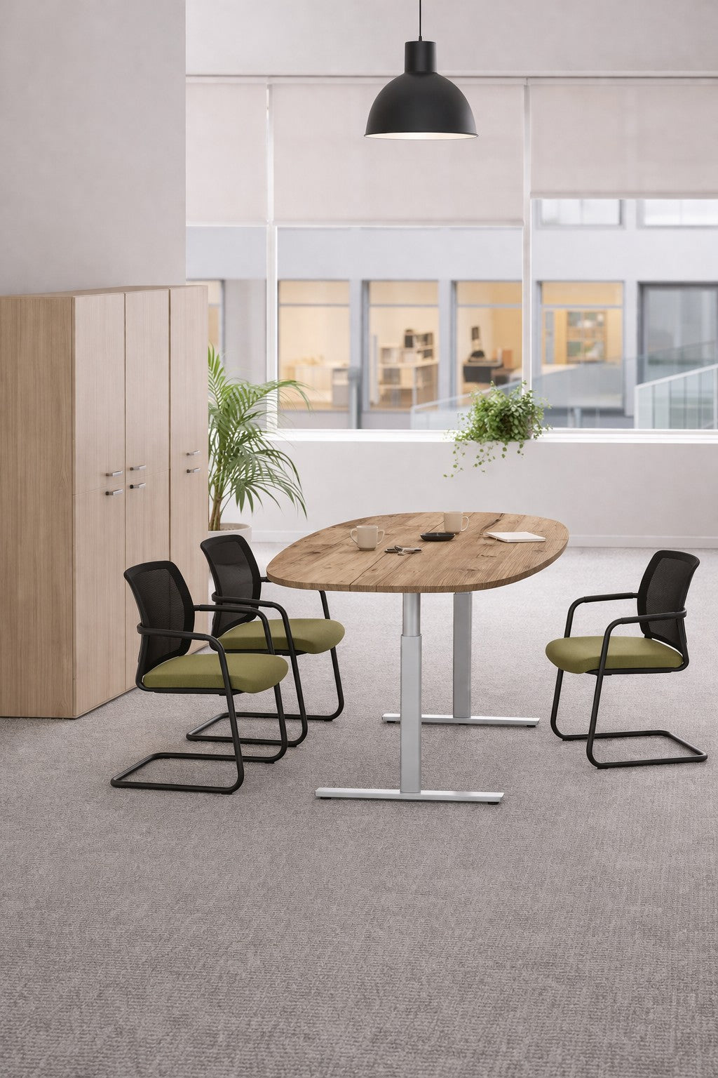 Un espace de réunion de bureau moderne avec un Monsieur Bureau Table tonneau électrique Top & Down pour 6-8 personnes, quatre chaises noires avec des coussins verts, une lampe noire suspendue, une armoire, une plante, et de grandes fenêtres donnant sur un autre bâtiment.#combo_timber_aluminium