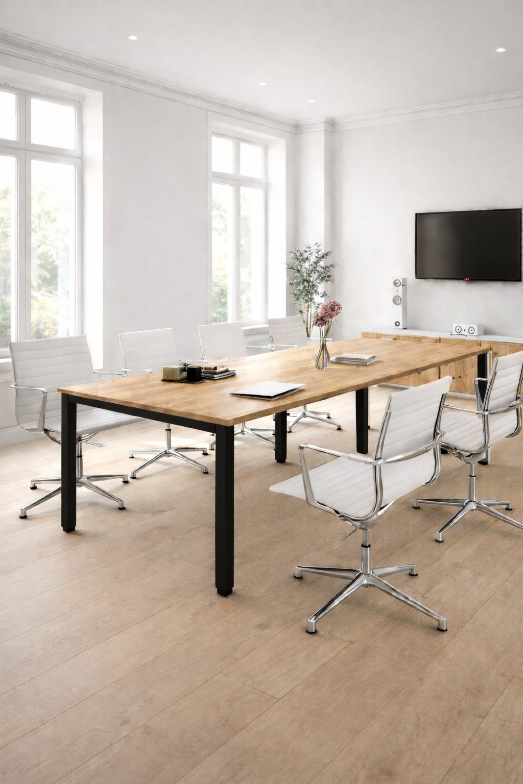 Une salle de conférence moderne avec la Table de réunion rectangulaire 6 à 14 personnes Tempo de Monsieur Bureau, des chaises pivotantes blanches, un vase à fleurs, une télévision murale, de grandes fenêtres avec de la lumière naturelle et un mobilier professionnel élégant.#combo_chene_veine_noir