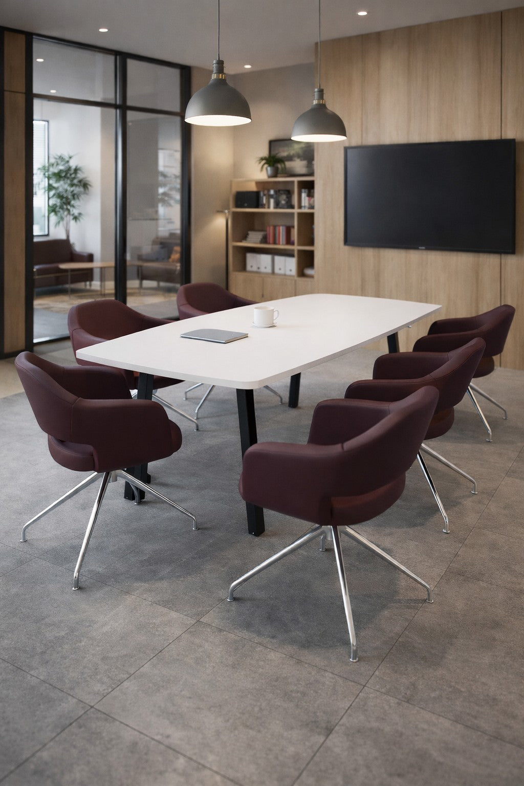 Salle de conférence moderne comprenant la Table de réunion tonneau ATMOSPHERIC 6 personnes de Monsieur Bureau, six chaises marron, un écran mural, une bibliothèque, de grandes fenêtres, deux lampes suspendues au-dessus de la table, ainsi qu'un cahier et un mug posés dessus..#combo_blanc_noir