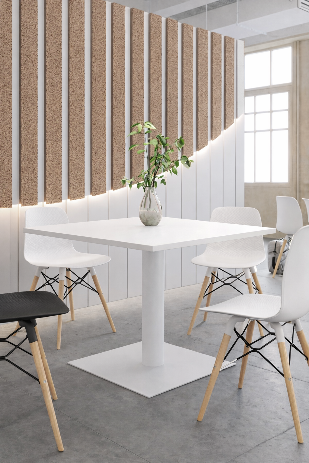 La table de collectivité Carrée Tempo - Plateau Stratifié de Monsieur Bureau, quatre chaises blanches avec des pieds en bois, un petit vase de feuilles vertes et des panneaux muraux verticaux en bois doucement éclairés constituent une salle à manger moderne et minimaliste.#combo_blanc_blanc
