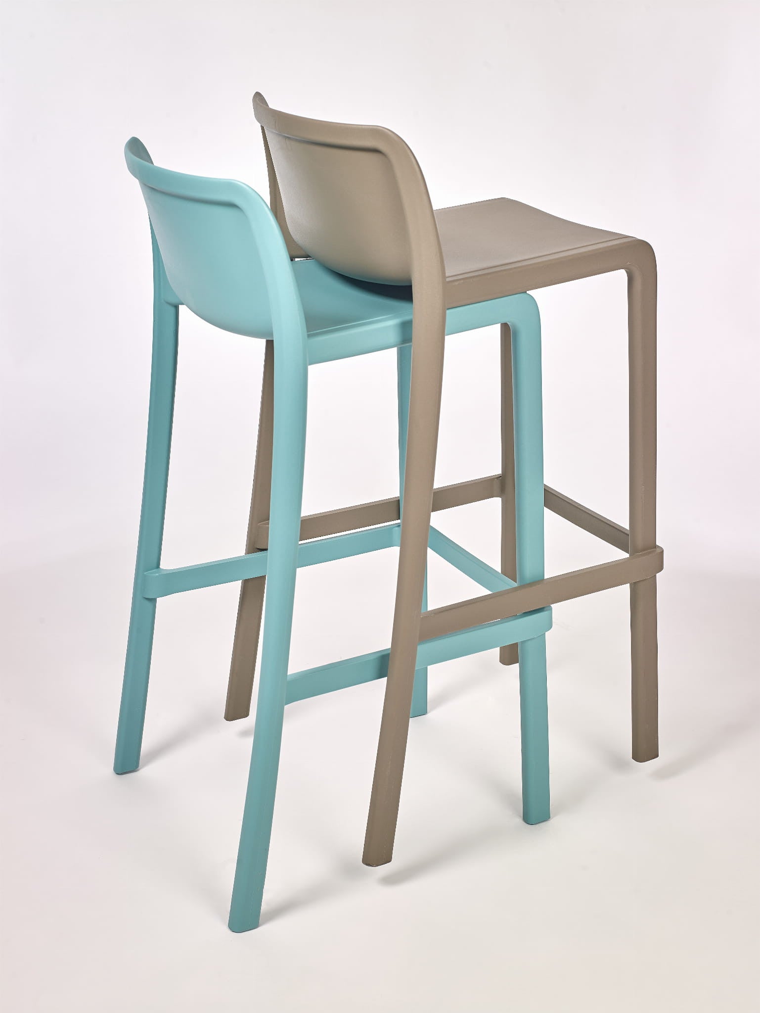 Deux Tabouret Haut Leus en Polypropylène Anti-UV de Monsieur Bureau, l'un bleu clair et l'autre beige, sont côte à côte sur un fond blanc. Leur design moderne et minimaliste se caractérise par des dossiers incurvés et des pieds élancés.